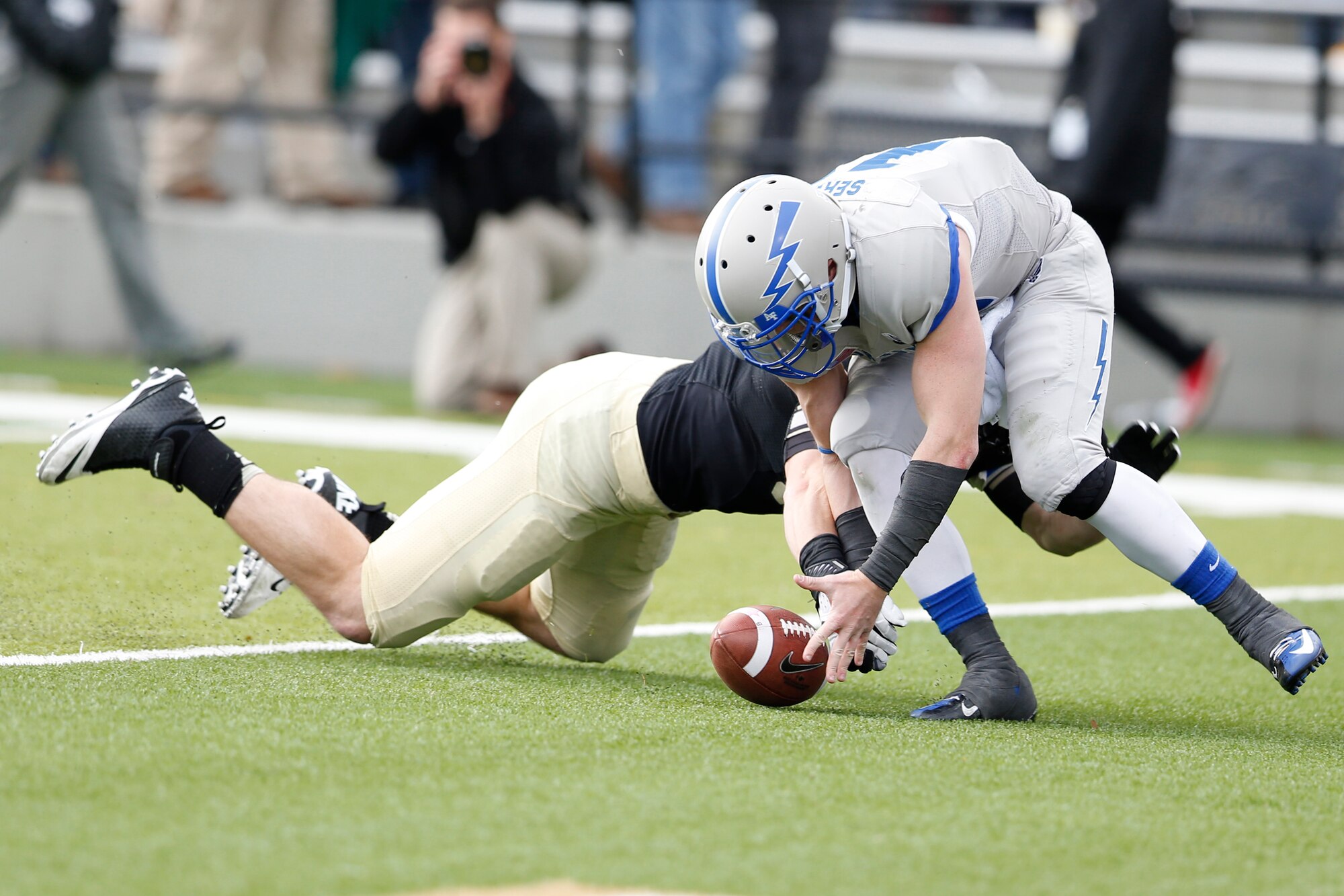 Air Force quarterback Connor Dietz and Army defensive lineman Joe Drummond fight for control of a fumble after a bad snap during the fourth quarter of the teams' match at Michie Stadium in West Point, N.Y., Nov. 3, 2012. Black Knights linebacker Nate Combs recovered the ball in the Falcons' end zone to take a 41-21 lead and kill Air Force's hopes for a comeback. (U.S. Air Force photo/Tommy Gilligan)