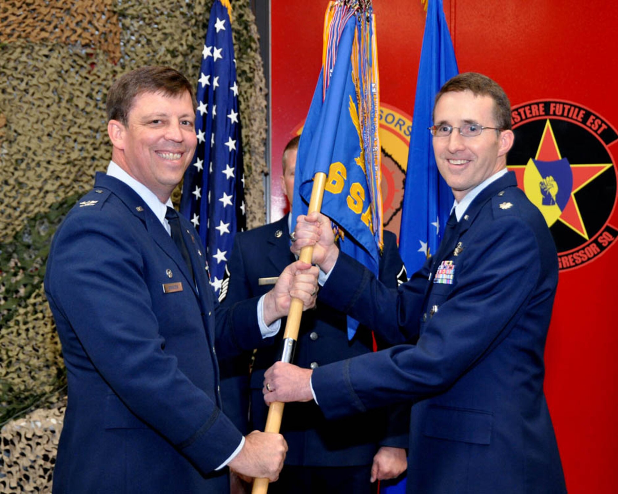 SCHRIEVER AIR FORCE BASE, Colo. -- (Right) Lt. Col. Daniel Bourque, 26th Space Aggressor Squadron, receives the guideon from Col. John Breeden, 926th Group commander, during his assumption of command ceremony at the Space Aggressor Warehouse on Nov. 3. (U.S. Air Force photo/Dan Santistevan)