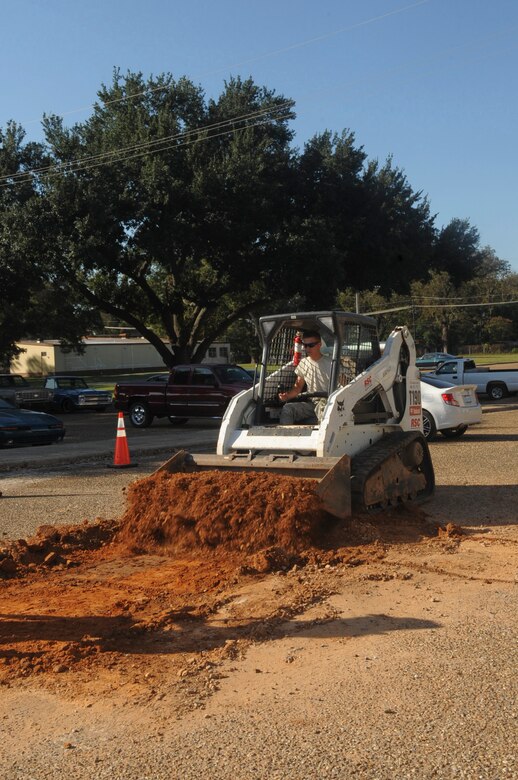 Senior Airman Gregory Heyl, 2nd Civil Engineer Squadron pavement and equipment journeyman, uses a Bobcat T190 to clear a pot hole on Barksdale Air Force Base, La., Oct. 31. The Airmen, known as Dirt Boys, use a variety of heavy equipment such as front-end loaders, bulldozers and backhoes to accomplish a number of tasks around the base. (U.S. Air Force photo/Senior Airman Kristin High)(RELEASED)
