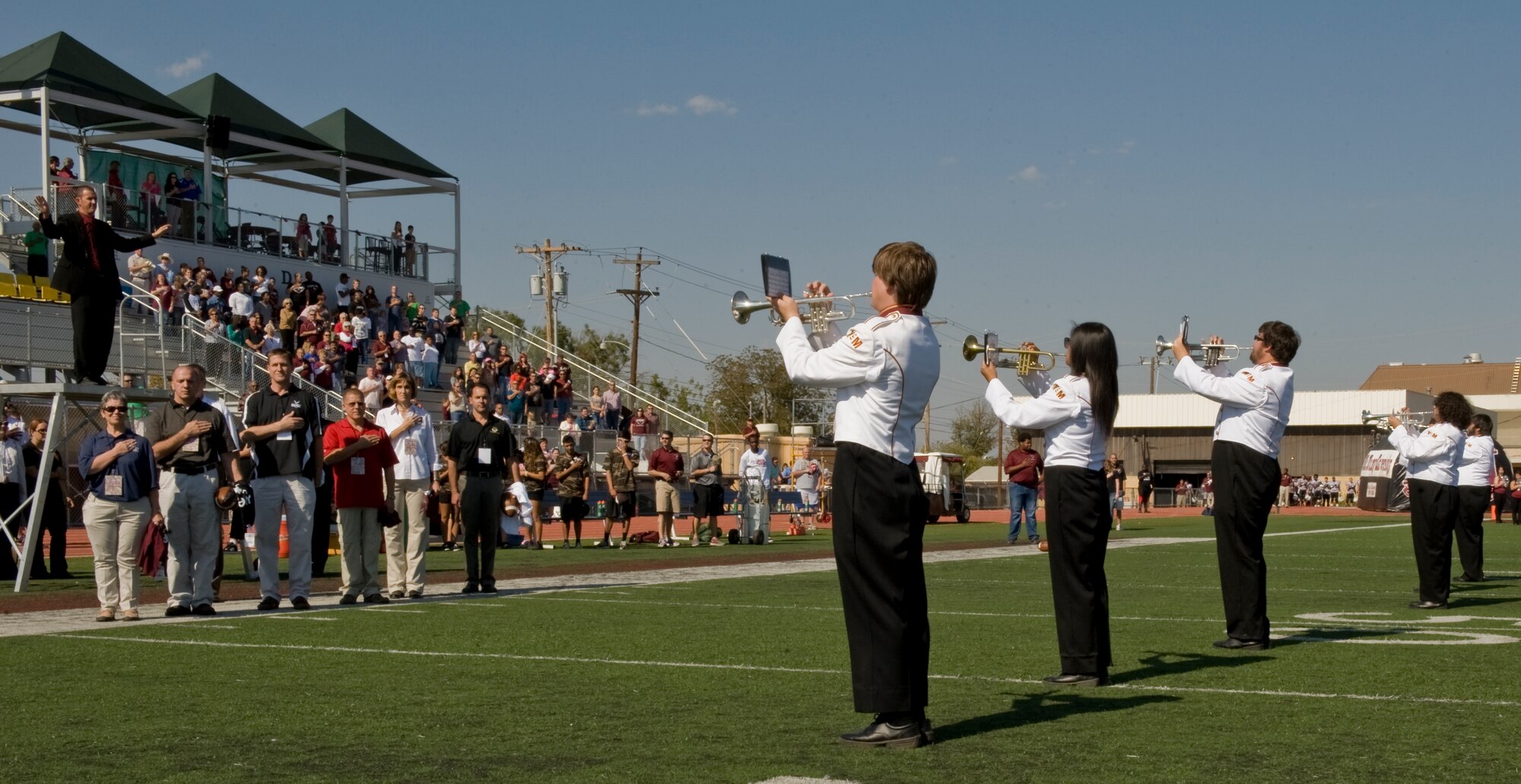 Spectators stand as the McMurry University band performs the national anthem during Military Appreciation Day Nov. 3, 2012, in Abilene, Texas. Military members and their families were honored with free food, a tailgate party and free entry to the McMurry University versus Texas College football game. (U.S. Air Force photo by Airman 1st Class Jonathan Stefanko/ Released)