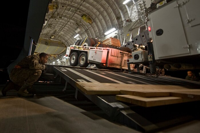 U.S. Air Force Maj. Craig Lane, 99th Logistics Readiness Squadron operations officer, watches as a truck and trailer are backed up into a C-17 Globemaster III from Travis Air Force Base, Calif., before being shipped to the East Coast to be used in relief efforts after Hurricane Sandy Nov. 5, 2012, at Nellis Air Force Base, Nev. NV Energy sent seven of their vehicles and 11 personnel on military aircraft to support Hurricane Sandy relief efforts in the Northeast. (U.S. Air Force photo by Senior Airman Daniel Hughes)