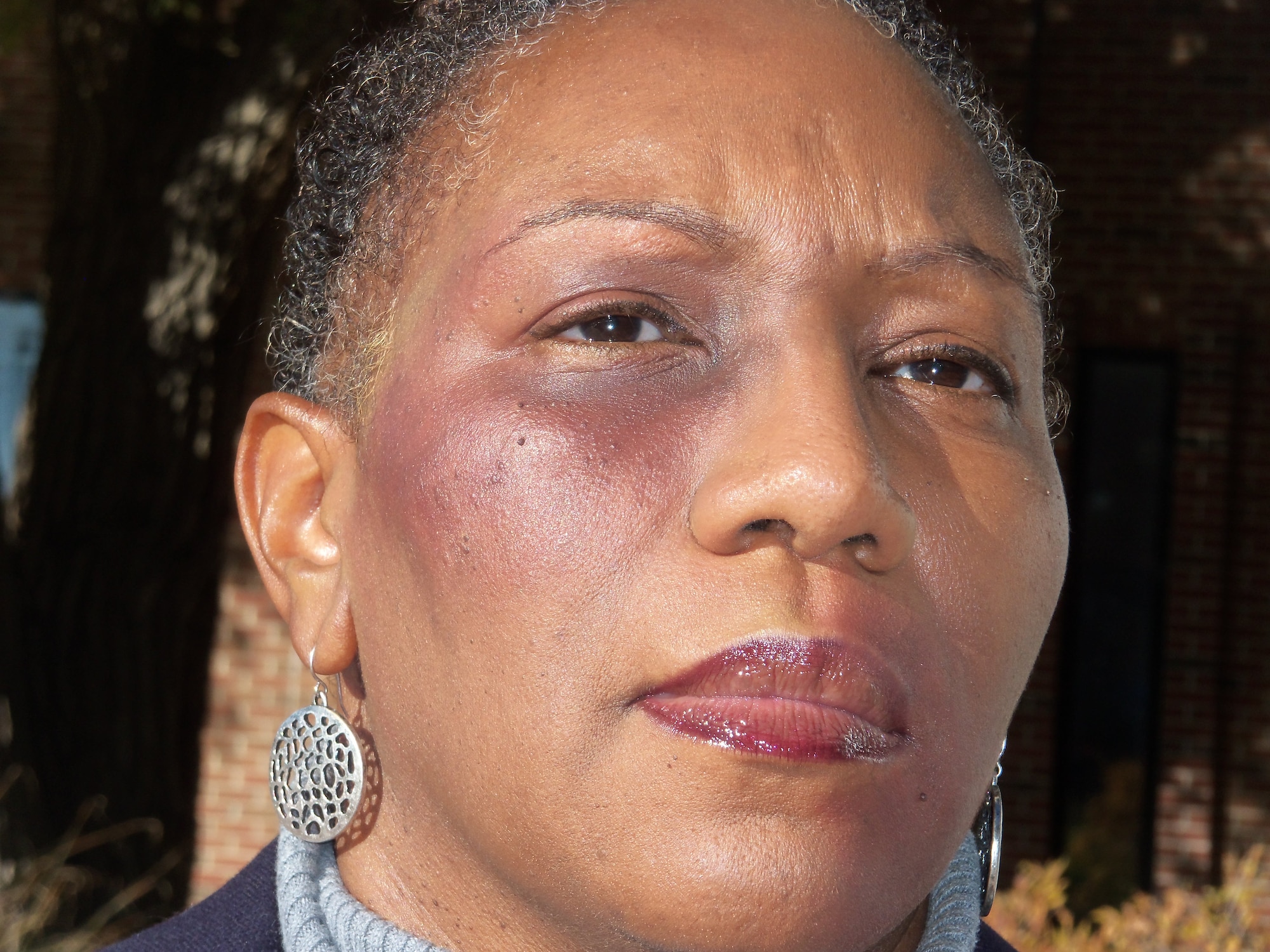 Martina Porter, Family Advocacy Program outreach manager, is one of seven volunteers made up to appear like she has a black eye for Domestic Violence Awareness Month, Oct. 18 at Peterson Air Force Base, Colo. The seven volunteers spent their day in makeup to see who, if anyone, would say something to them. Only a few bystanders asked, and those who did were provided a bookmark with information for victim resources. (U.S. Air Force photo/Shirley Crow)
