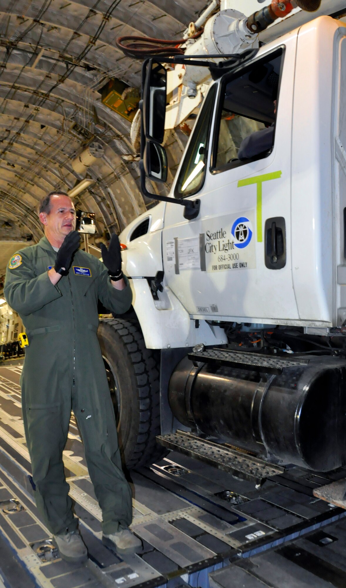 Master Sgt. Robert Bertsch, a loadmaster from McChord Field's 446th Airlift Wing, unchains a truck from Seattle City Light at John F. Kennedy International Airport in Jamaica, N.Y., Nov. 4. The crew of five Resesrvists loaded and flew 55,000 pounds of cargo and 9 power crew members to help with Hurricane Sandy relief efforts. (U.S. Air Force Photo/Staff Sgt. Rachael Garneau)