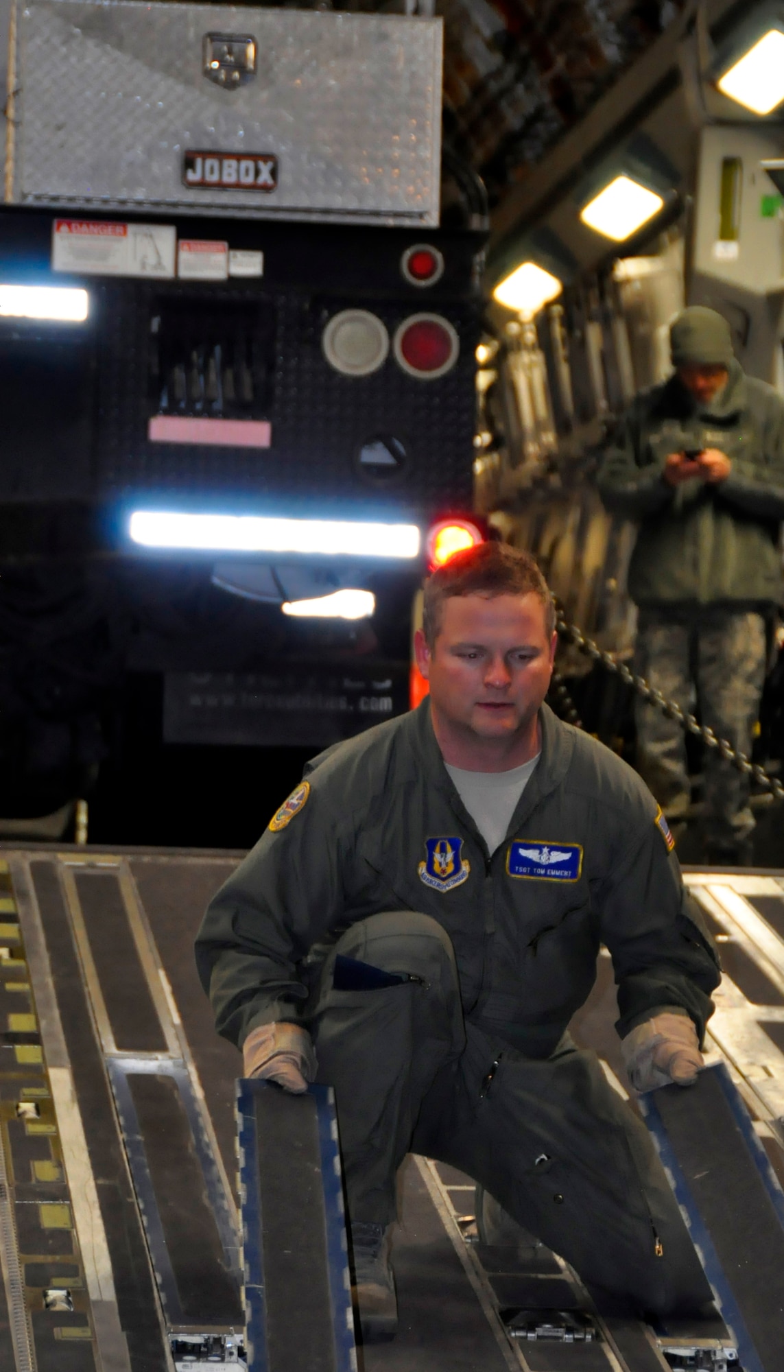 Tech. Sgt. Tom Emmert, a loadmaster from McChord Field's 446th Airlift Wing, prepares to unload a truck from Seattle City Light at John F. Kennedy International Airport in Jamaica, N.Y., Nov. 4. The crew of five Resesrvists loaded and flew two trucks and 9 power crew members from Washington state to help with Hurricane Sandy relief efforts. (U.S. Air Force Photo/Staff Sgt. Rachael Garneau)