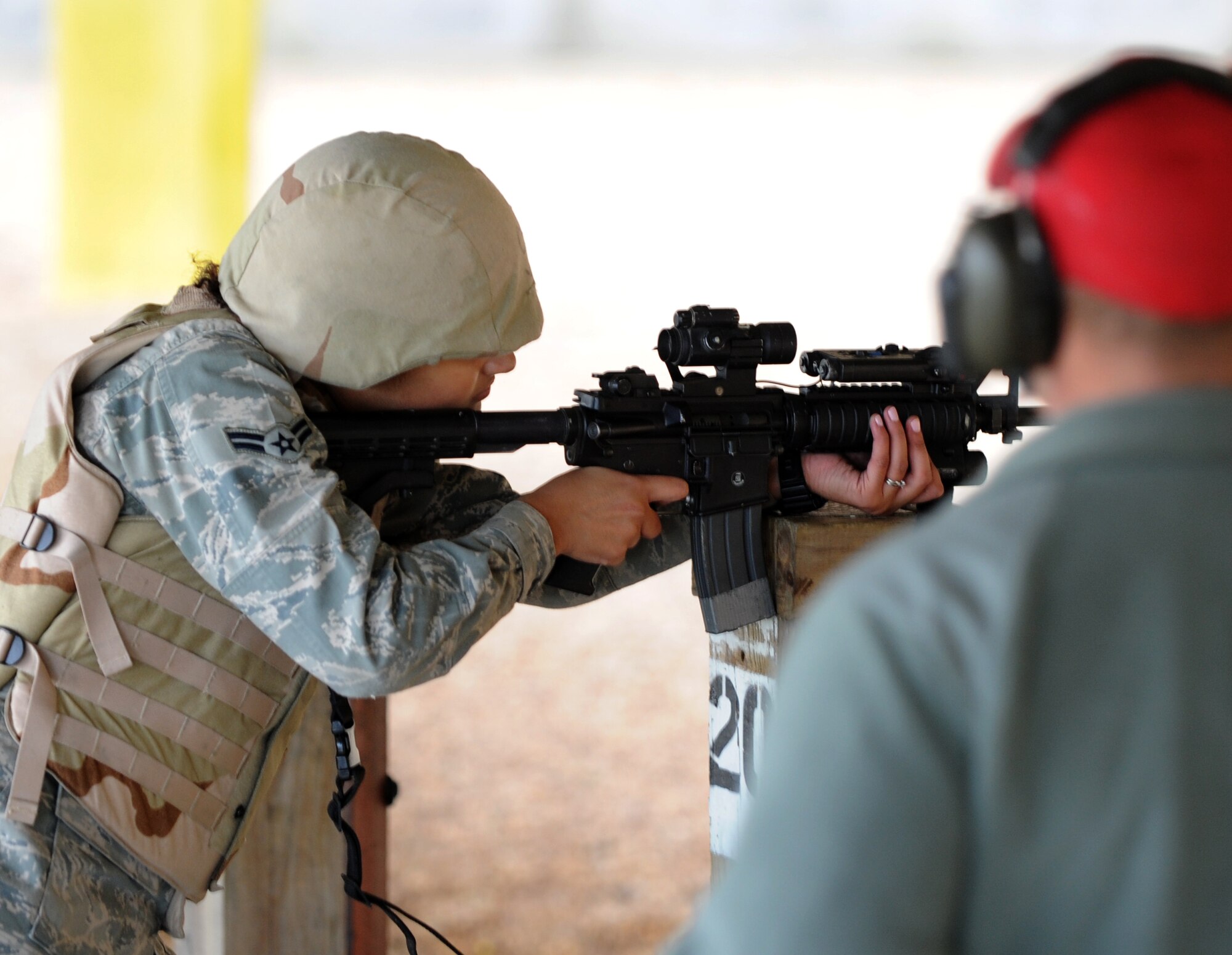 U.S. Air Force Staff Sgt. Jostin Schaffer, right, 633rd Security Forces Squadron combat arms instructor, watches Airman 1st Class Tiana Zakariyya, 633rd SFS member, fire downrange at Langley Air Force Base, Va., Nov. 1, 2012. Security Forces personnel maintain weapons qualifications with hands-on firing experience. (U.S. Air Force photo by Senior Airman Racheal E. Watson/Released)