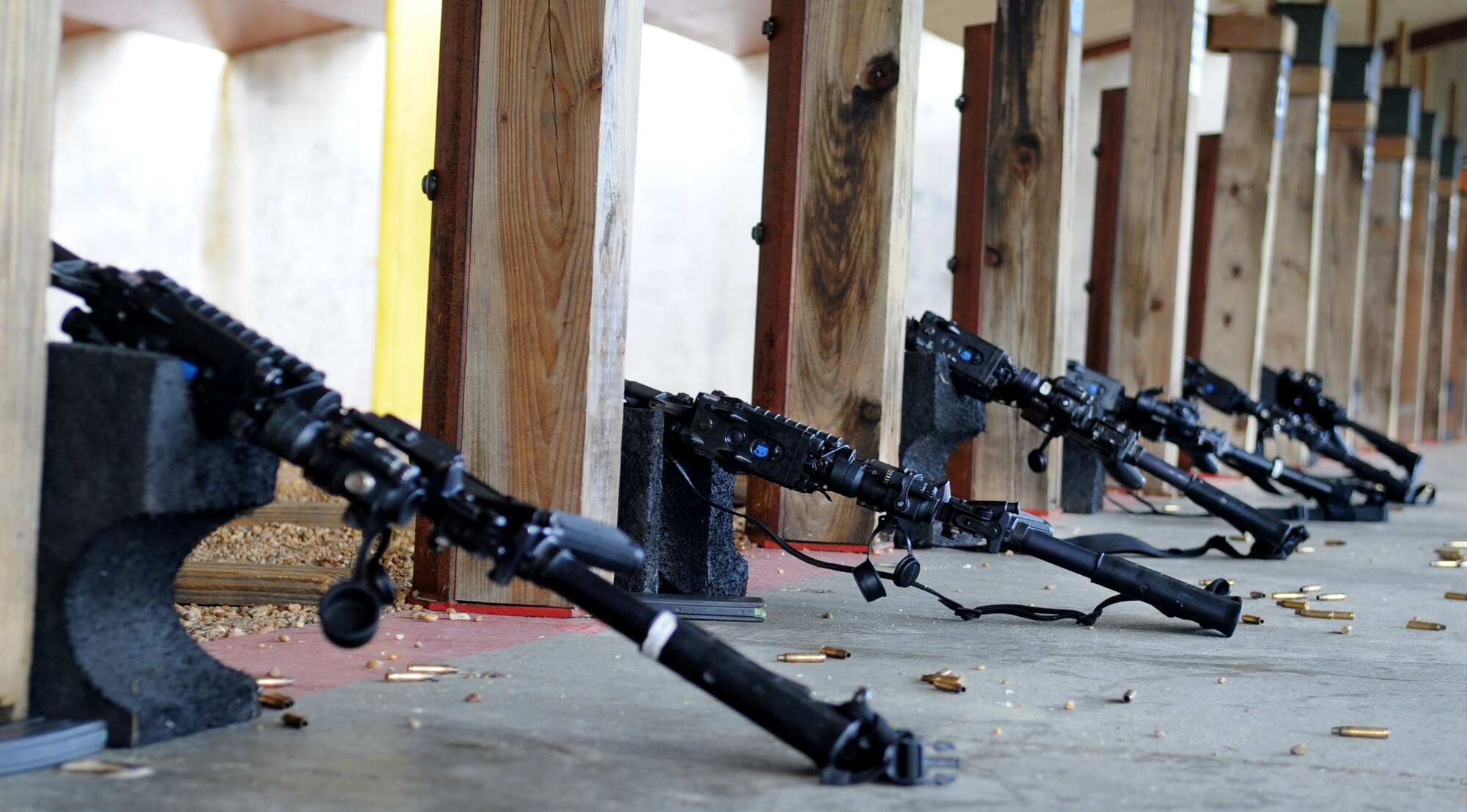 Several 5.56mm M4 Carbines sit propped on stands during Combat Arms Training and Maintenance training at Langley Air Force Base, Va., Nov. 1, 2012. Security Forces personnel demonstrate proper safety measures when scoring the targets downrange. (U.S. Air Force photo by Senior Airman Racheal E. Watson/Released)