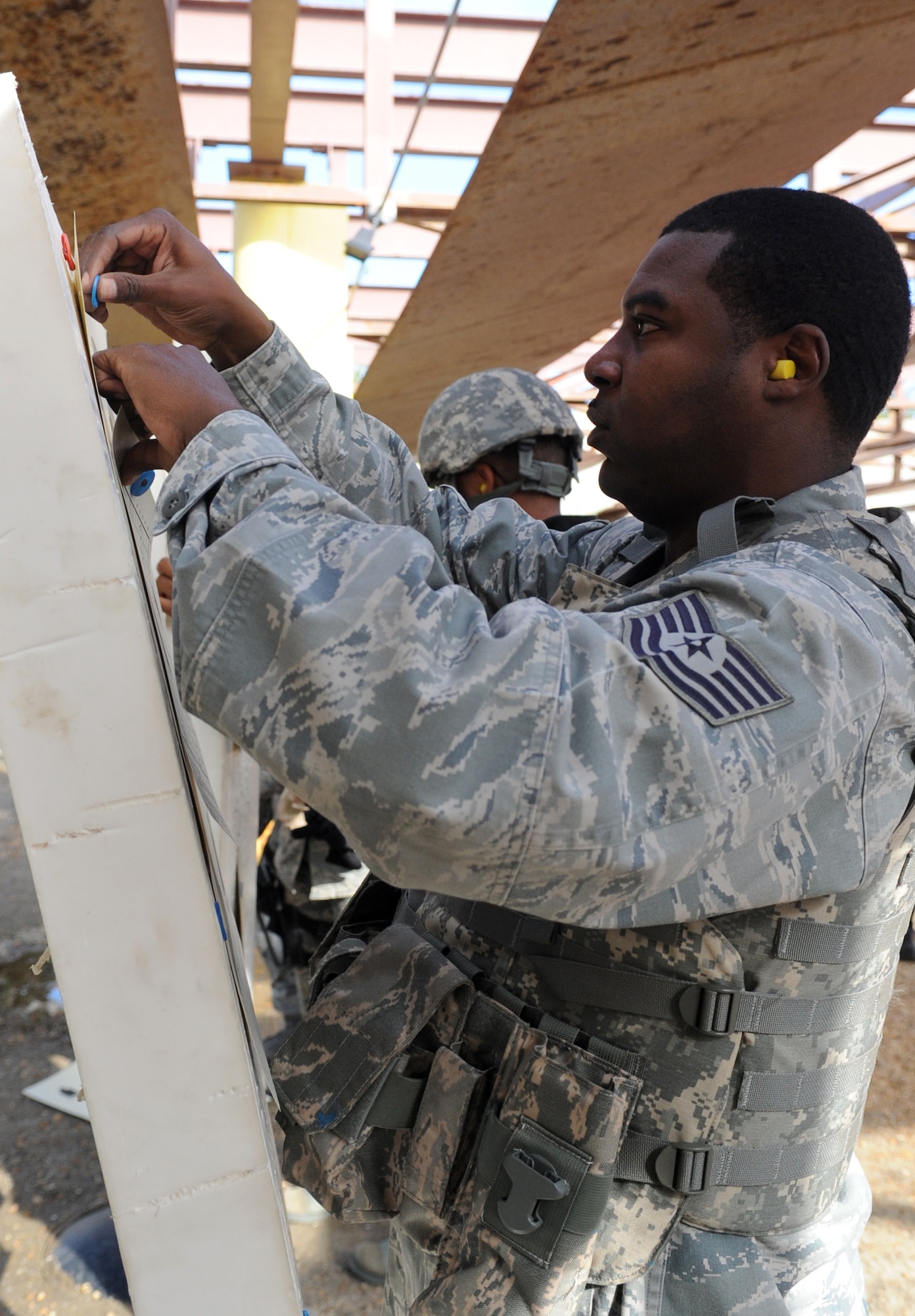 U.S. Air Force Tech. Sgt. Demond Cleveland, 633rd Security Forces Squadron operations member, pins up his Combat Arms Training and Maintenance qualifying target at Langley Air Force Base, Va., Nov. 1, 2012. Security Forces personnel maintain weapons qualifications through hands-on firing experience and classroom instruction. (U.S. Air Force photo by Senior Airman Racheal E. Watson/Released)