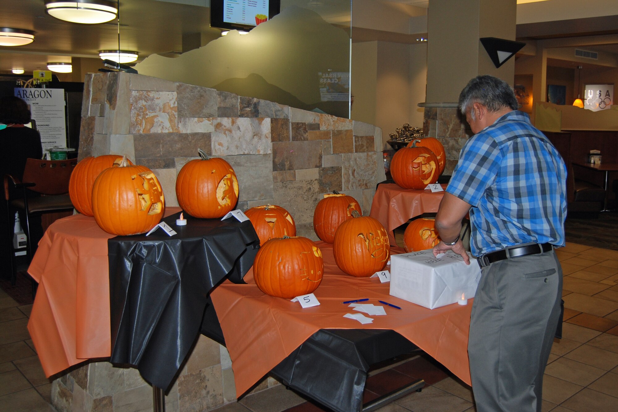 PETERSON AIR FORCE BASE, Colo. — A lunchtime diner at the Aragon Dining Facility votes for his favorite pumpkin carving Oct. 31. Members from the DFAC carved the pumpkins as a group. The only rule was pumpkins had to be carved during a designated 90 minute timeframe. Results were: First, Staff Sgt. Mary Cousin; second, Tech. Sgt. Robert Newman; third, Senior Airman Candace Philippo. (U.S. Air Force photo/Lea Johnson)
