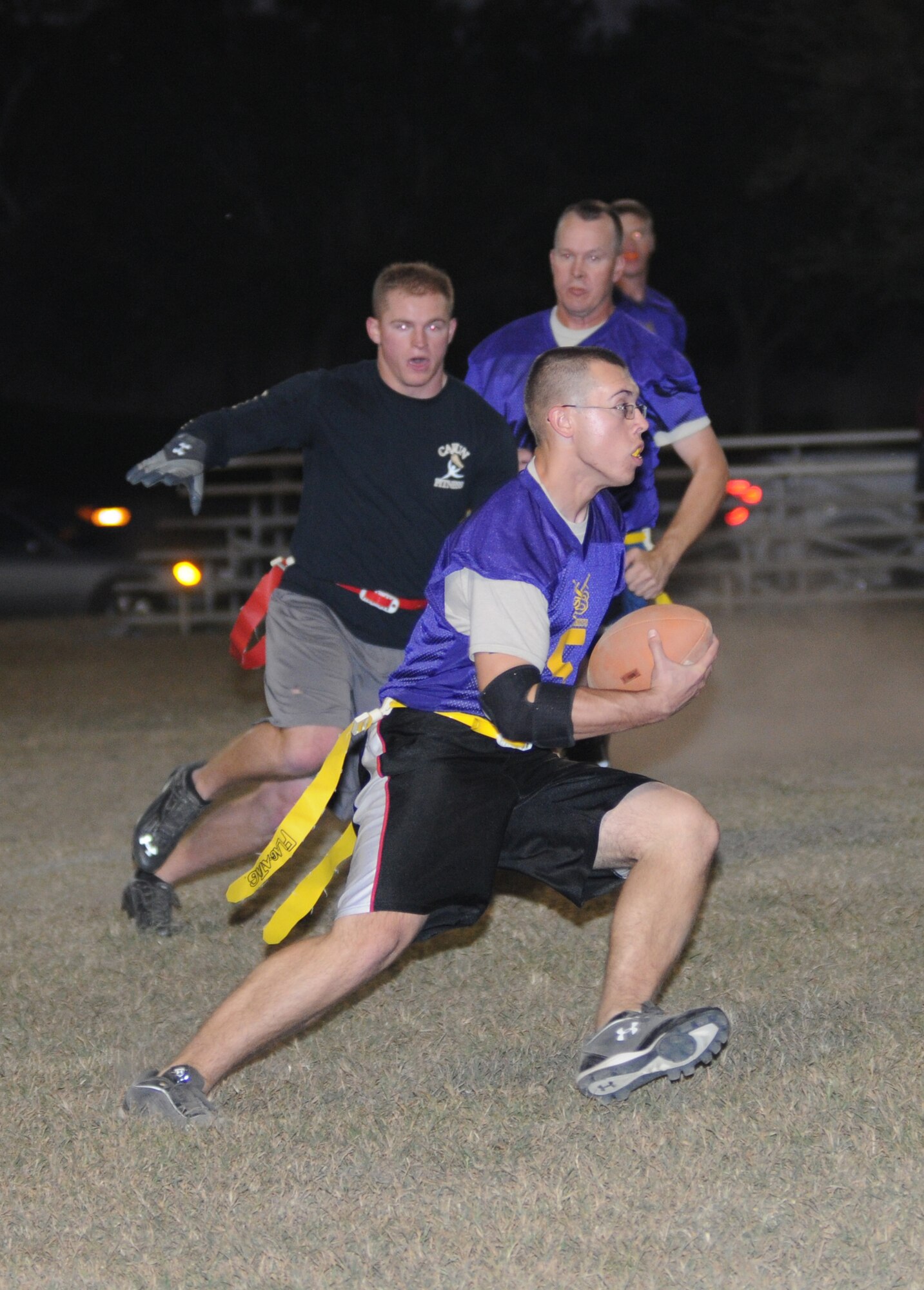 Erin Chiasson, 335th Training Squadron, chases Collin Benton, 338th Training Squadron quarterback, down the field as he runs the ball with Raymond Somero close behind during an intramural flag football game Nov. 1, 2012, at Keesler Air Force Base, Miss.  The Bulls defeated the Dark Knights, 26-20.  (U.S. Air Force photo by Kemberly Groue)