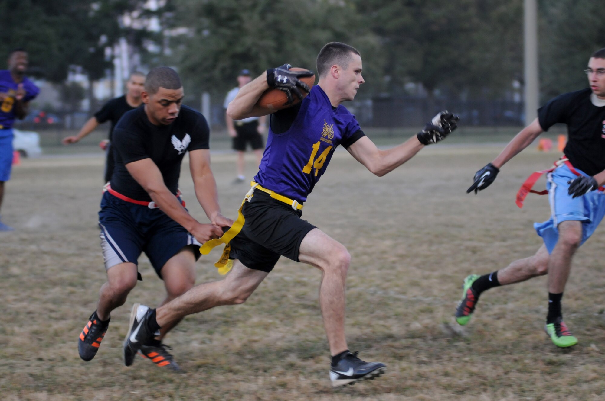 Zellie Dow, 335th Training Squadron, grabs the flag of Isaiah Maylott, 338th Training Squadron, as he runs the ball down the field during an intramural flag football game Nov. 1, 2012, at Keesler Air Force Base, Miss.  The Bulls defeated the Dark Knights, 26-20.  (U.S. Air Force photo by Kemberly Groue)