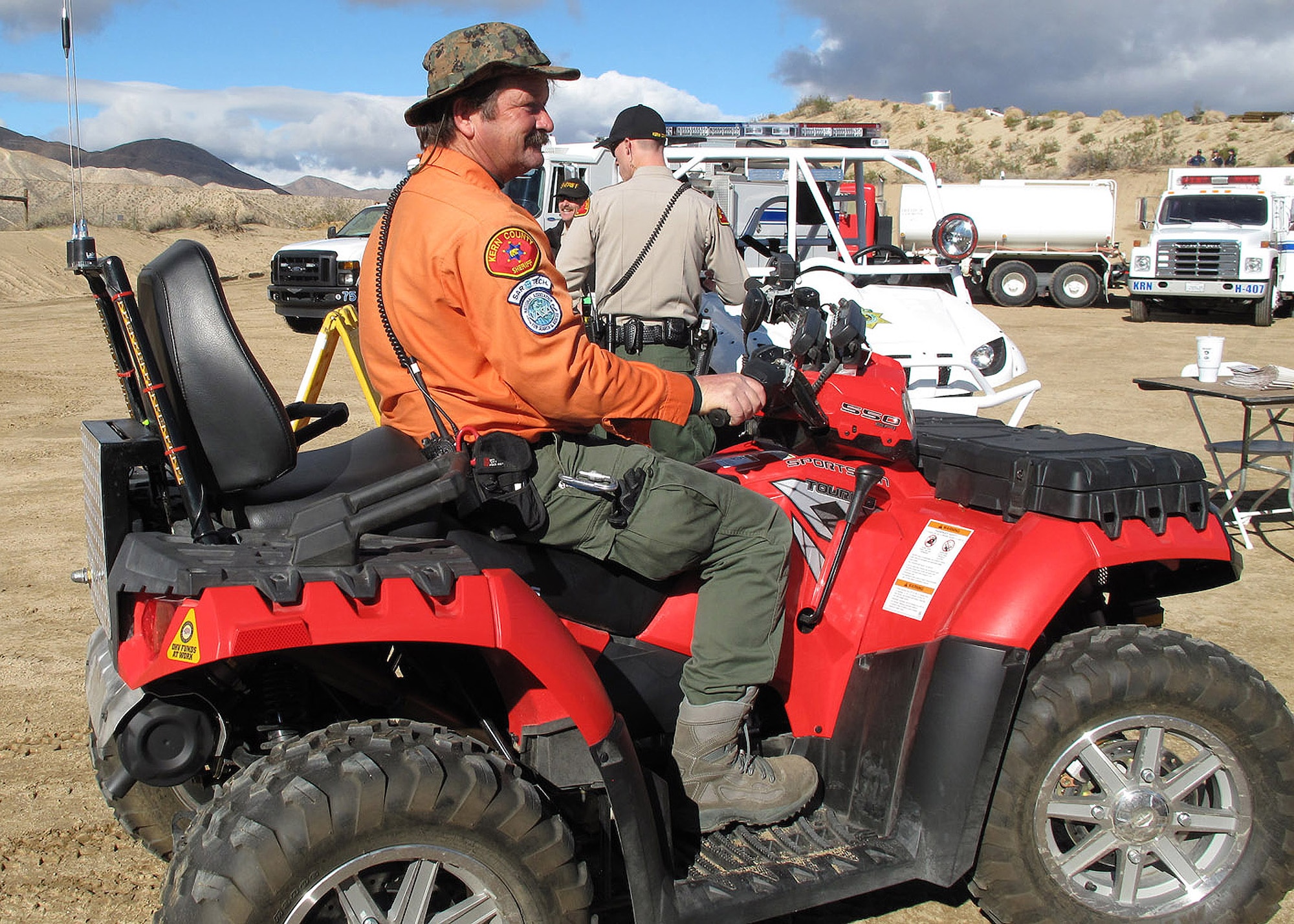 Randy Glass, 412th Maintenance Group (Joint Strike Fighter), sits upon one of the all terrain vehicles the SAR team uses to navigate the desert when called upon.  The Kern County Sheriff's SAR team is on call 24/7 and assists local law enforcement when needed.  (Courtesy photo)