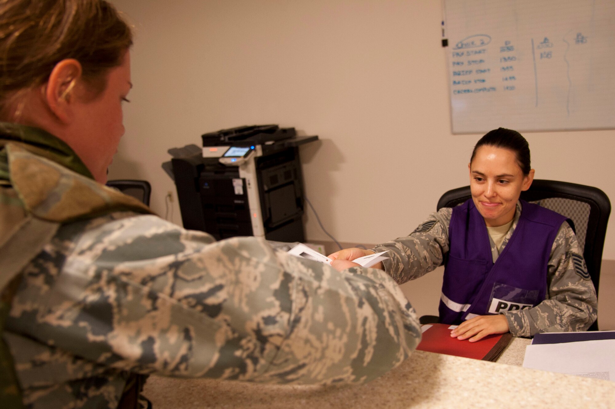 VANDENBERG AIR FORCE BASE, Calif. – Tech Sgt. Brittany Spoutz, 30th Force Support Squadron readiness non-commissioned officer, gives information on the services provided through the Airman & Family Readiness Center for the deployers and their family members at the Installation Deployment Readiness Center here Friday, Nov. 2, 2012. The deployment line check information in the deployers folders and inform them of services provided during deployments. (U.S. Air Force photo/Senior Airman Lael Huss)