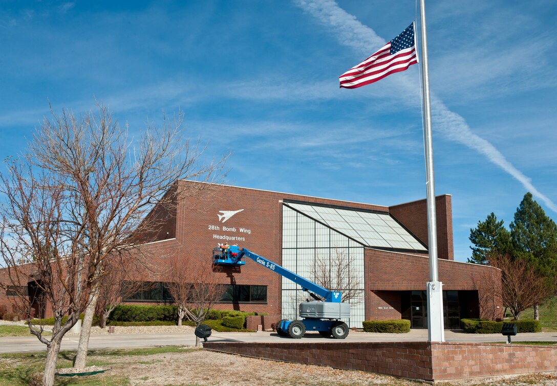 Senior Airman Michael Maze, and Staff Sgt. Amanda Fischer, 28th Civil Engineer Squadron structural technicians, affix a MQ-9 Reaper image to the front of the 28th Bomb Wing Headquarters building to signify the importance of the 432nd Attack Squadron’s mission at Ellsworth Air Force Base, S.D., Oct. 29, 2012. The 432nd ATKS remotely employs MQ-9 Reaper aircraft from ground control facilities located at Ellsworth in support of worldwide combatant commander requirements. (U.S. Air Force photo by Airman 1st Class Zachary Hada/Released)