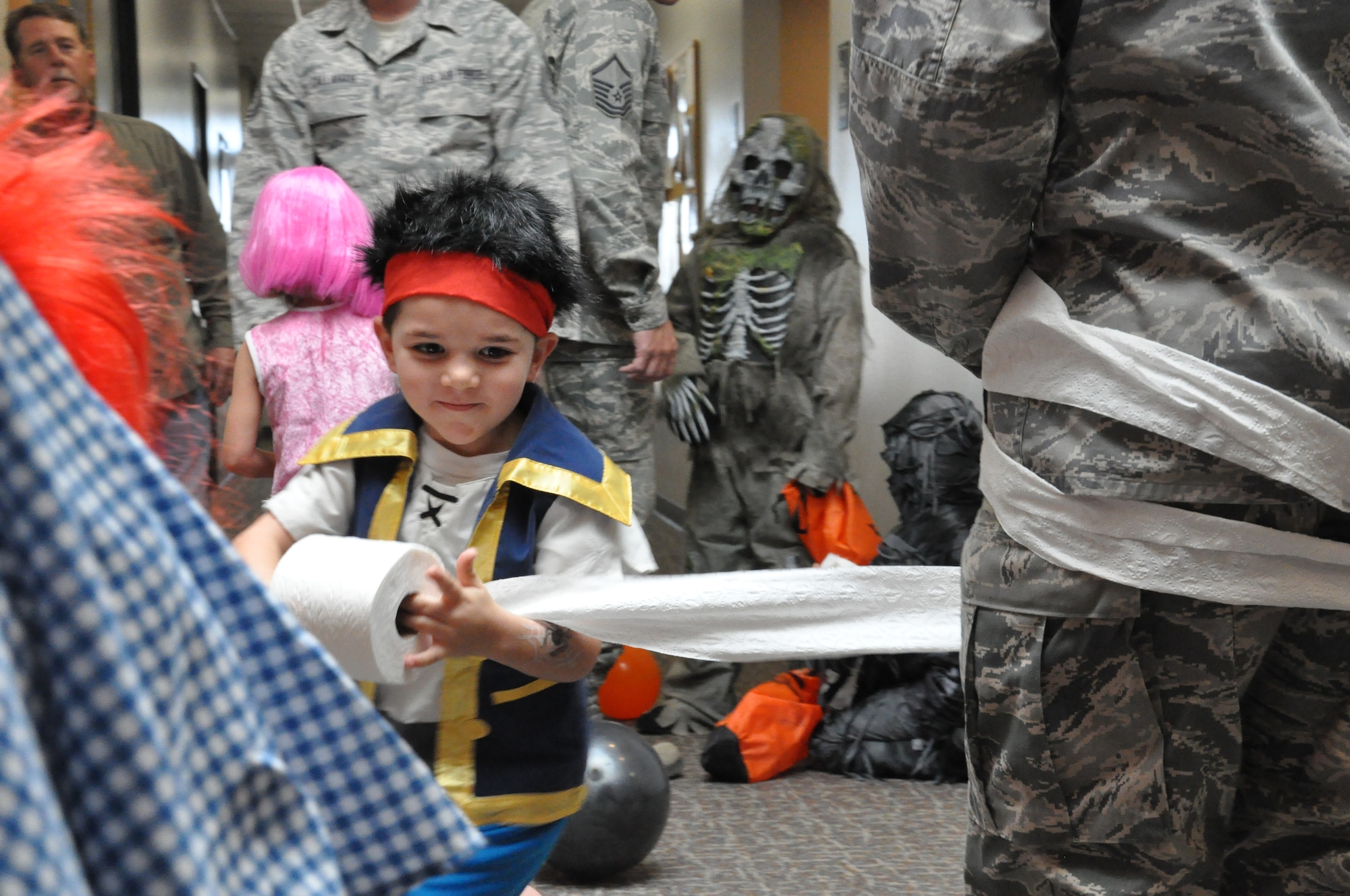 BUCKLEY AIR FORCE BASE, Colo. – A child runs wildly around his father, Tech. Sgt. Matthew Sullivan, 460th Space Communications Squadron, wrapping him like a mummy Oct. 31, 2012, at a Halloween event. The 460th SCS hosted the event for the squadron’s members and families. (U.S. Air Force photo by Staff Sgt. Nicholas Rau)  