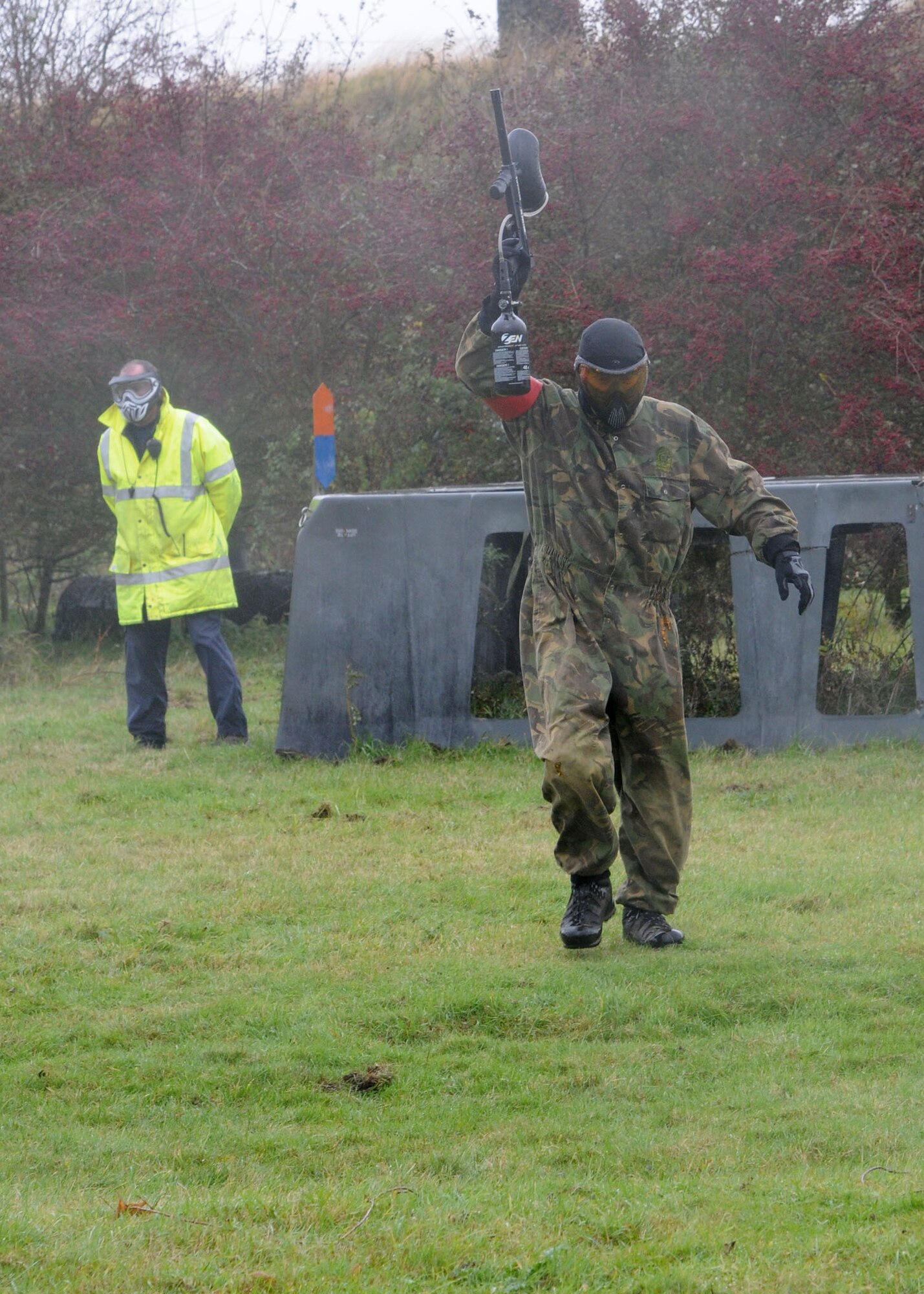A service member from the RAF Alconbury and RAF Molesworth team holds his paintball gun above his head in surrender as he exits the playing field during the Single Airman Retreat Paintball Tournament Nov. 3, 2012, on RAF Molesworth, England. Players were tagged out of each 10-minute game if they were shot and the paint ball broke on their coveralls. (U.S. Air Force photo by Airman 1st Class Kelsey Waters/Released)