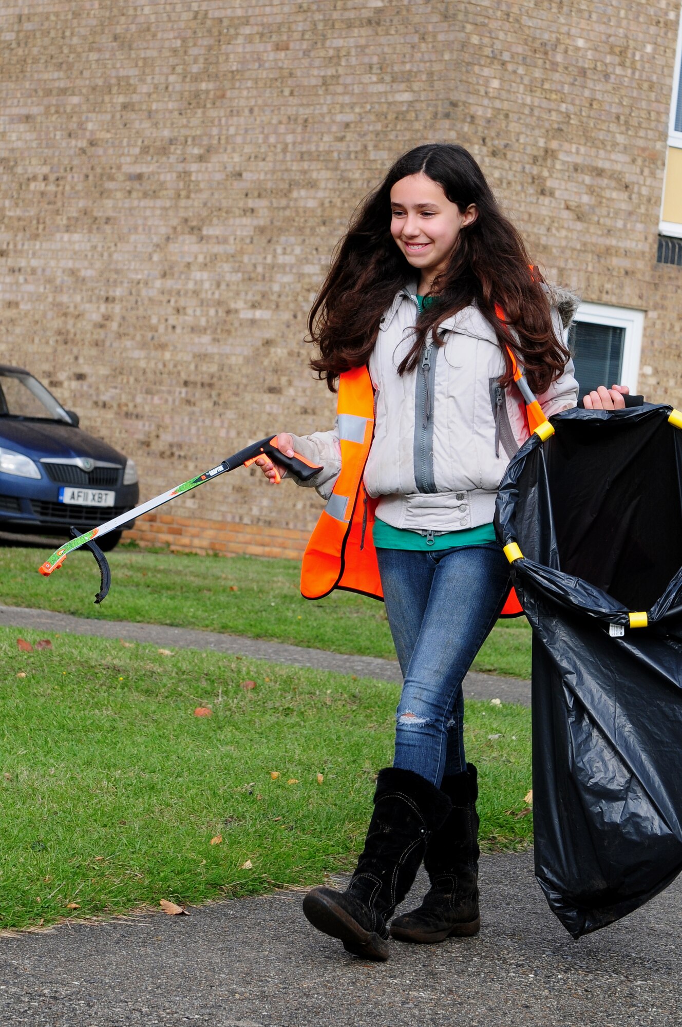 ROYAL AIR FORCE LAKENHEATH, England – Jasmine Clark, daughter of Tech. Sgt. James Clark, 48th Medical Surgical Squadron medical technician, searches for litter to pick up during a Lord’s Walk base housing clean up Nov. 3, 2012. Clark recently had her 10th birthday and instead of asking for material gifts, she asked to help clean up her community. Residents of Lord’s Walk came out to clean up litter around their neighborhood, and the Forest Heath District Council assisted, as well as donated two trees for children to plant.  (U.S. Air Force photo by Airman 1st Class Cory D. Payne)