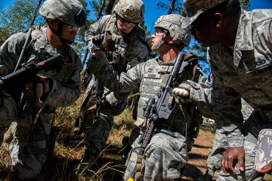 U.S. Air Force Joseph Ostrum, 823d Base Defense Squadron alpha squad leader, communicates with his team during improvised explosive device lane training as Chief Master Sgt. James Davis, 9th Air Force command chief, listens in at Moody Air Force Base, Ga., Nov. 1, 2012. Davis tagged along during the training session to witness how the unit handles possible IED situations in a deployed environment. (U.S. Air Force photo by Staff Sgt. Jamal D. Sutter/Released) 