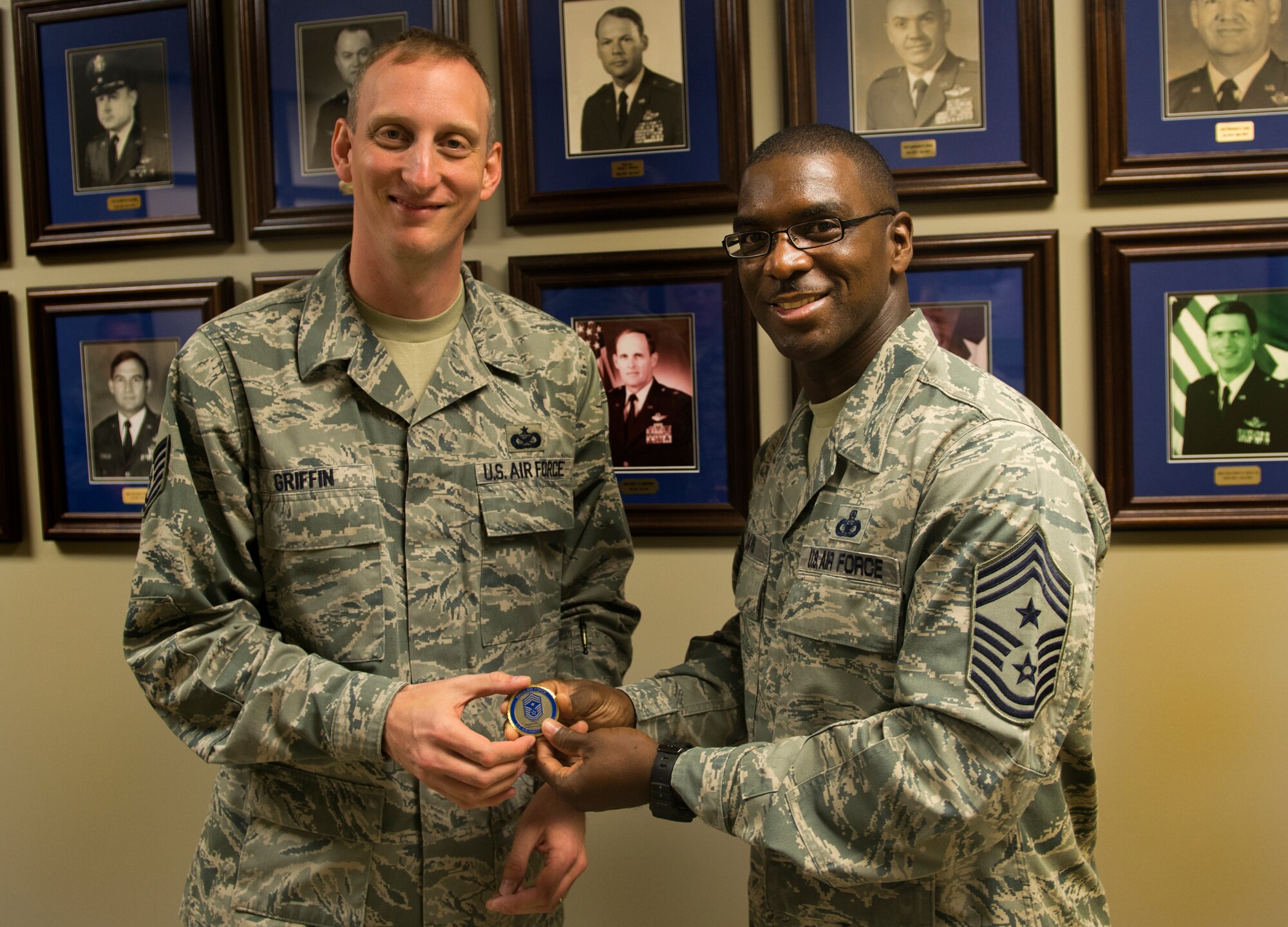 U.S. Air Force Chief Master Sgt. James Davis, 9th Air Force command chief, presents a coin to Tech. Sgt. Alex Griffin, 23d Wing Public Affairs operations NCO in-charge, at Moody Air Force Base, Ga., Oct. 31, 2012. Griffin received the coin for his commitment and dedication to the planning and execution of the Legacy of Liberty Open House air show. (U.S. Air Force photo by Senior Airman Douglas Ellis/Released)
