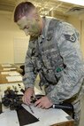 Air National Guard Staff Sgt. Mathew Oleson, fire team leader for the 115th Security Forces Squadron, dismantles an M-4 carbine rifle during weapons qualification training at Truax Field in Madison, Wis. on November 3.  Approximately 30 Airmen from the 115th Fighter Wing Security Forces Squadron participated in the training exercise, which focused on improving combat readiness and weapons familiarization.
