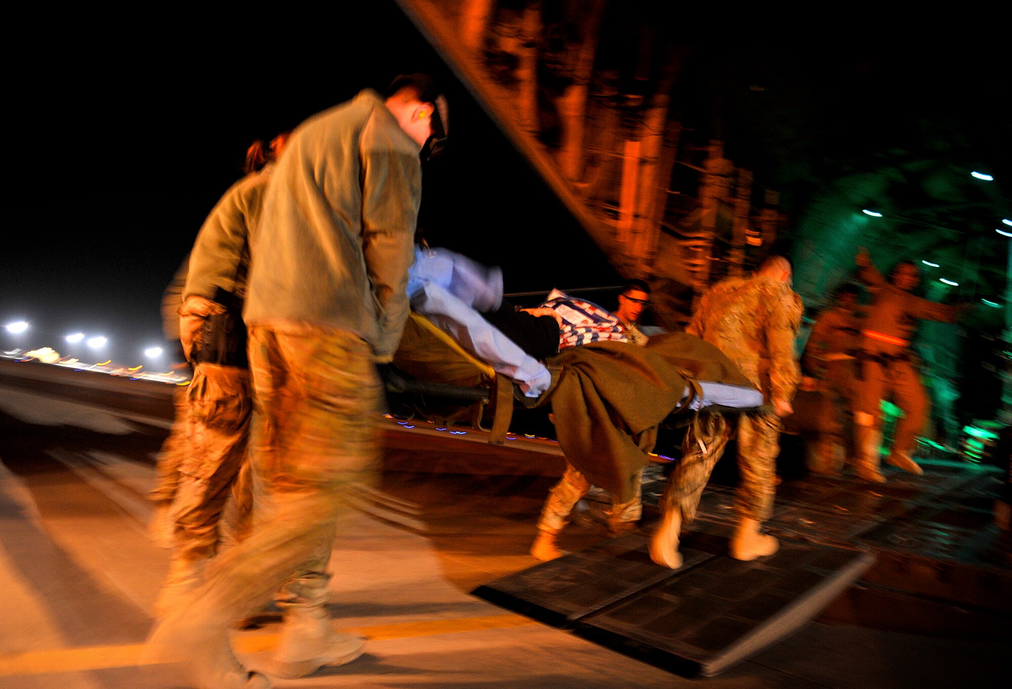 U.S. Air Force members transport an injured patient onto a C-130 Hercules during an aeromedical evacuation mission at Camp Bastion, Afghanistan, Oct. 21, 2012. The aeromedical flights are used to transport injured or recovered patients with the NATO Role 3 hospital and the Contingency Aeromedical Staging Facility based at Kandahar Airfield. The CASF staff at Kandahar is 28 members strong and performs tasks ranging from helping medevac patients off of the helicopters they come in on to providing warm beds for their outgoing temporary residents. (U.S. Air Force photo/Staff Sgt. Clay Lancaster)