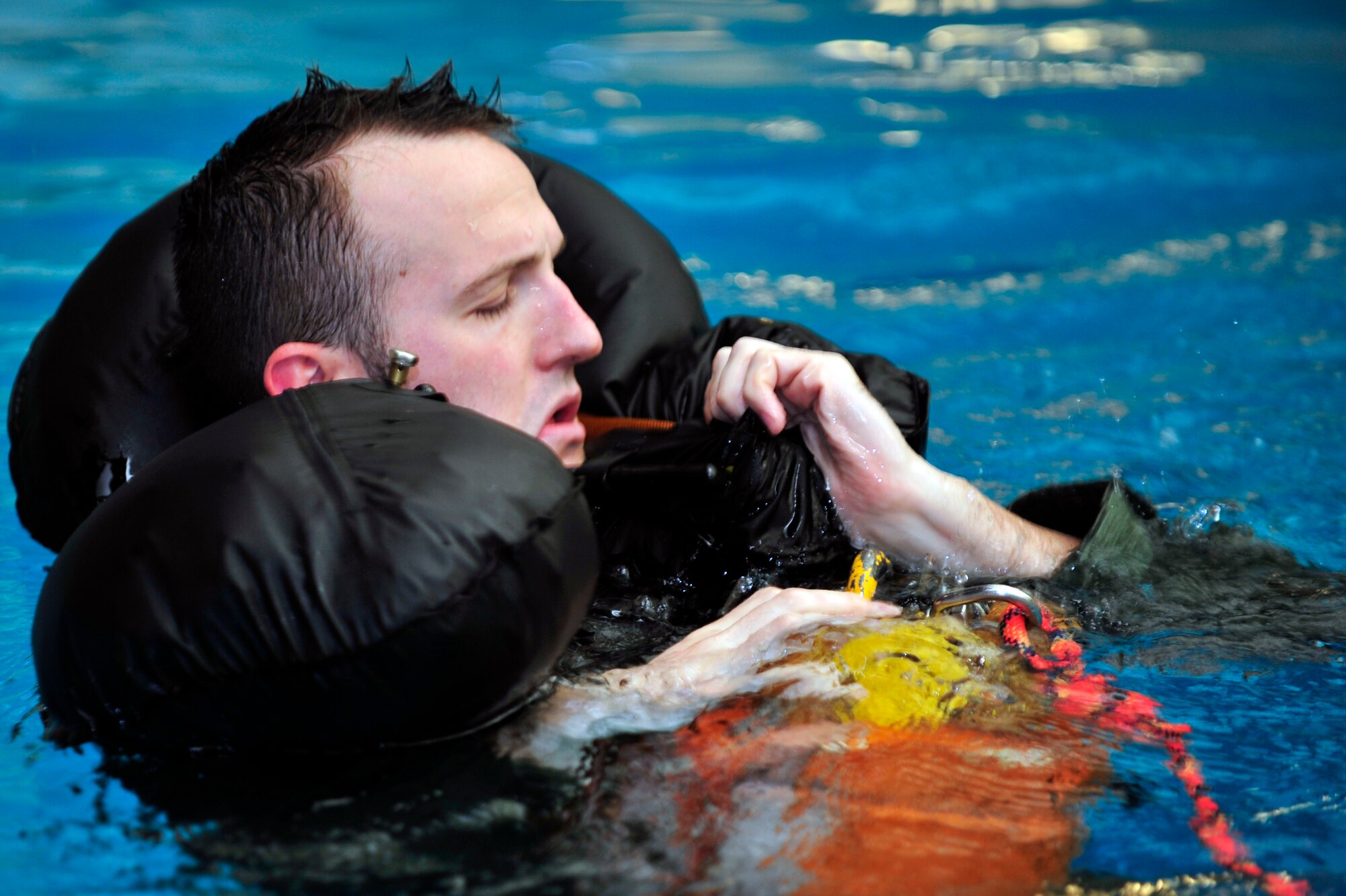 Capt. Ricky Greer, 36th Fighter Squadron pilot, prepares for a recovery during a water survival evaluation at the Osan Air Base pool, Nov. 5, 2012. Osan’s Survival, Evasion, Resistance and Escape instructors work to refresh pilots’ water survival skills by allowing them to demonstrate their knowledge on their equipment, wildlife hazards and how to signal for recovery. (U.S. Air Force photo/Airman 1st Class Alexis Siekert)