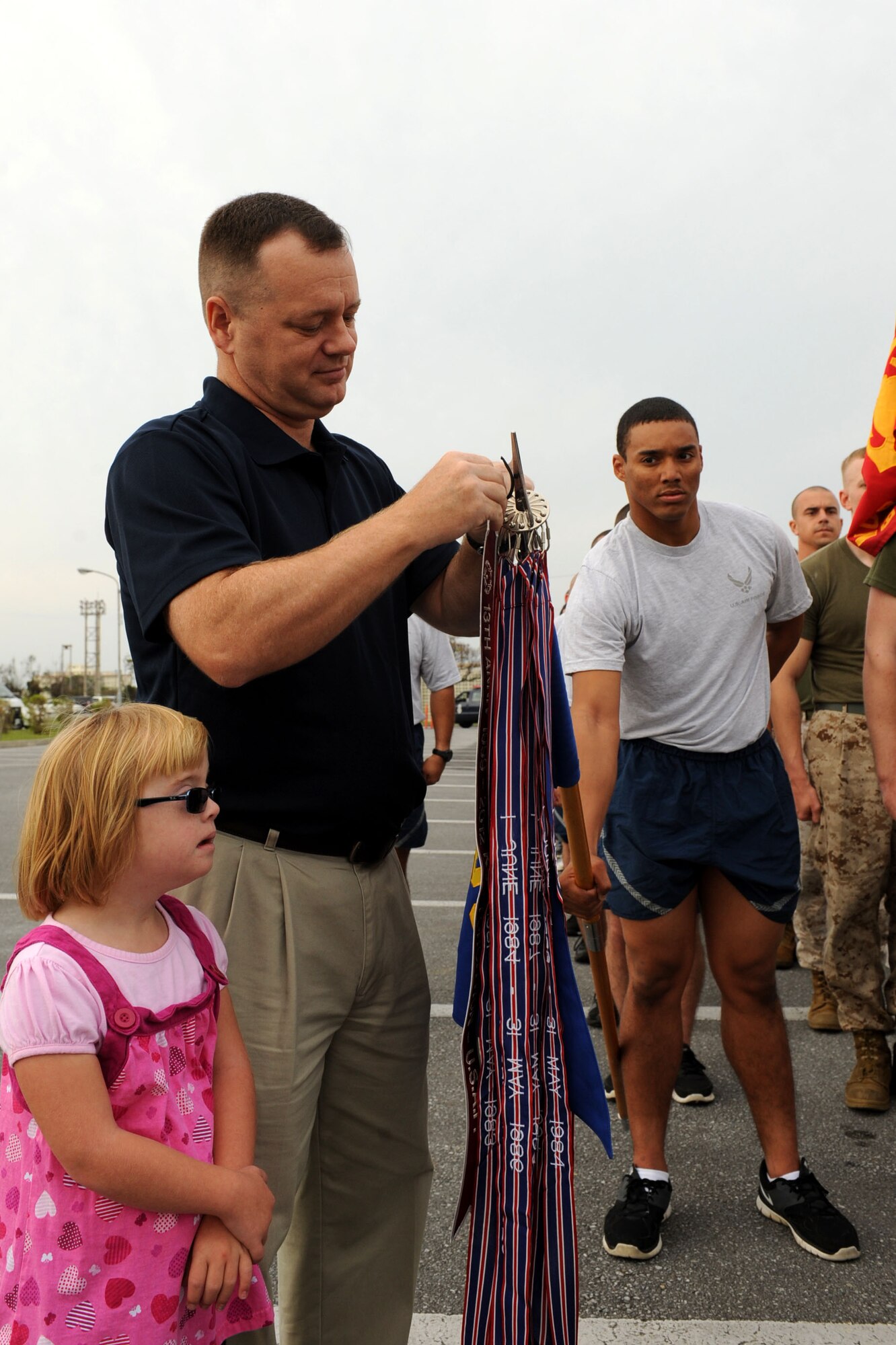 U.S. Air Force Col. Brian McDaniel, 18th Wing vice commander, attaches a streamer to the Air Force guide-on after law enforcement Airmen, Marines, Sailors and Soldiers ran together for the annual Special Olympics Torch Run on Kadena Air Base, Japan, Nov. 3, 2012. The torch run began in 1981 when law enforcement officers in Wichita, Kan. saw the need to raise funds for Special Olympics. The 13th Annual Kadena Special Olympics is scheduled for Nov. 17. (U.S. Air Force photo/Airman 1st Class Brooke P. Beers)