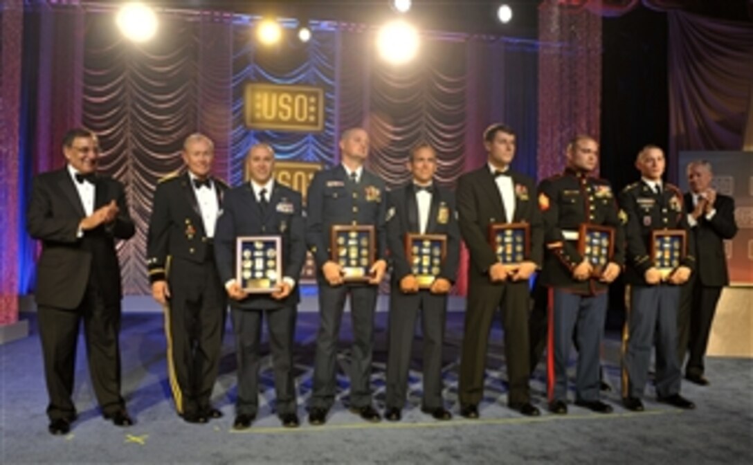 Secretary of Defense Leon E. Panetta, left, applauds as service members of the year are recognized on stage during the 2012 USO Gala in Washington, D.C., on Nov. 2, 2012.  Chairman of the Joint Chiefs of Staff Gen. Martin E. Dempsey, second from left, joined Panetta in honoring, from left, National Guardsman of the Year Senior Airman Evan J. Stevens, Coast Guardsman of the Year Petty Officer 2nd Class Nicholas A. Beane, Airman of the Year Staff Sgt. Christopher S. Beversdorf, Sailor of the Year Petty Officer 2nd Class Gregory F. Gaylor, Marine of the Year Sgt. Clifford M. Wooldridge and Soldier of the Year Staff Sgt. Jacob J. Perkins.  Retired Gen. Richard B. Myers, right, joined in the celebration.  