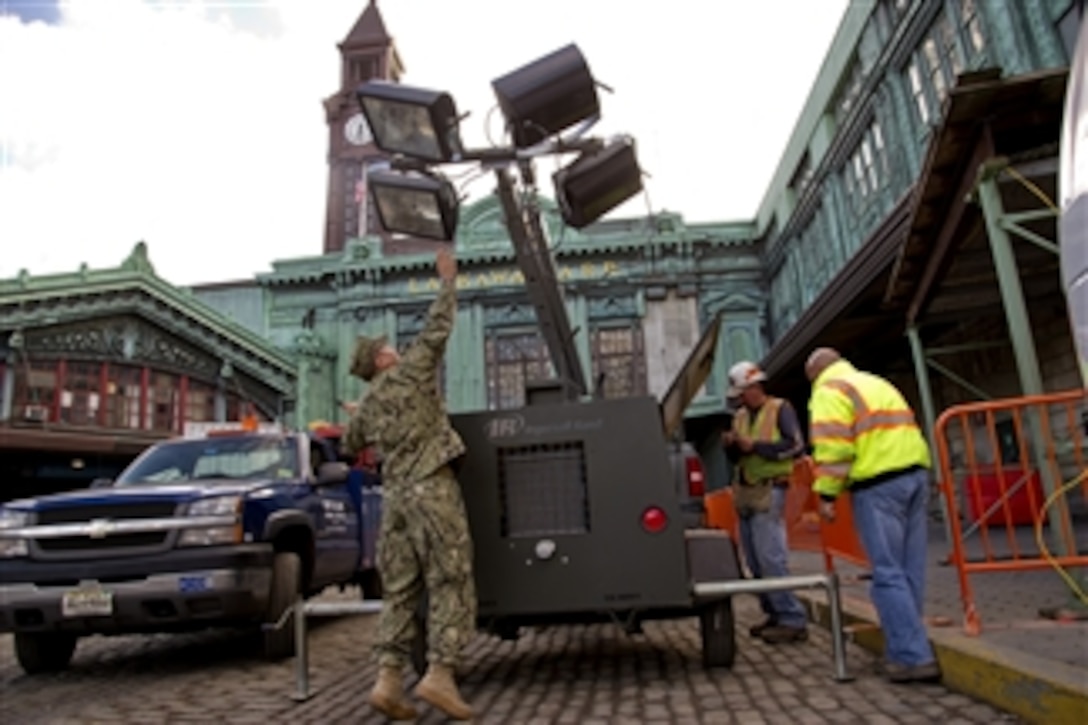 A sailor from Coastal Riverine Squadron 4 helps to erect a ten-kilowatt light plant at the Hoboken Transit Terminal in Hoboken, N.J., on Nov. 4, 2012.  Members of all the Armed Forces are providing relief support to areas affected by Hurricane Sandy.  