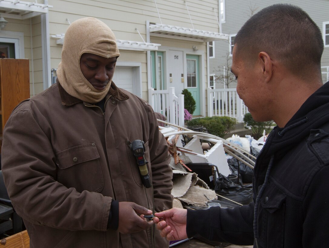 Sgt. Michael F. Blake, a motor transportation clerk with 1st Marine Corps District, accepts the keys to Sgt. Julian Ranas’ truck Nov. 1 in front of Blake’s home in Far-Rockaway, N.Y.  After losing three vehicles to the storm and living without electricity, Blake intends to use Ranas’ vehicle to keep warm, charge his cellular phone and stay connected with his loved ones.  Ranas is 1MCD’s enhanced marketing vehicle driver.