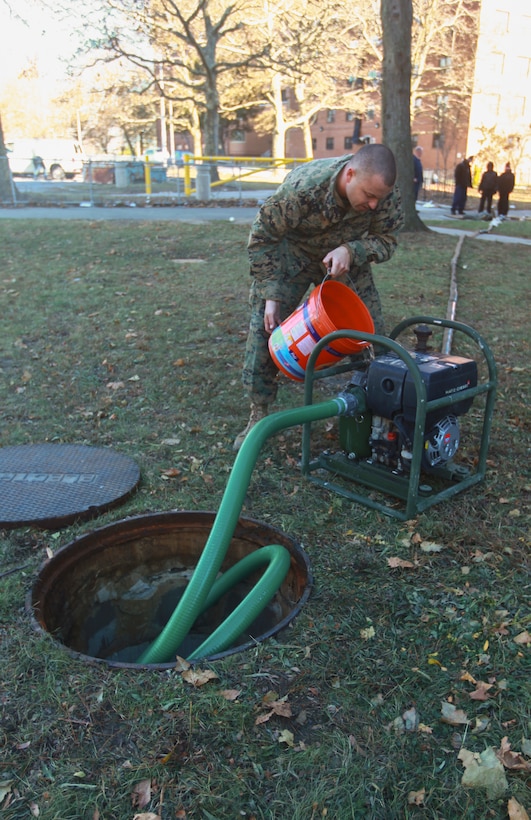 Gunnery Sgt. Justin Gober, a native of Jacksonville, FL., a combat engineer with a detachment of 8th Engineer Support Battalion, 2nd Marine Logistics Group based out of Camp Lejeune, N.C., primes the water pump before beginning to clear the water out of the basement of an apartment complex in Far Rockaway, N.Y. on Nov. 4. The detachment of Marines from 8th ESB volunteered to help aide the victims of the cities that were effected by Hurricane Sandy.  (Official Marine Corps photo by Cpl. Caleb Gomez)