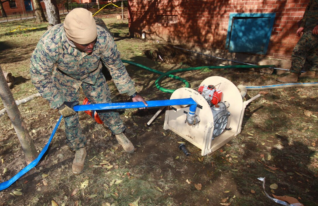 Cpl. Smith Thenor, a native of Fort Lauderdale, Florida, a combat engineer with a detachment of 8th Engineer Support Battalion, 2nd Marine Logistics Group based out of Camp Lejeune, N.C., prepares a pump to excavate water out of the basement of an apartment building in Far Rockaway, N.Y. on Nov. 4. The detatchment of Marines from 8th ESB volunteered to help aide the victims of the cities that were effected by Hurricane Sandy.  (Official Marine Corps photo by Cpl. Caleb Gomez)