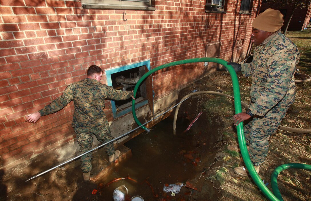 Sgt. Justin Armstrong (left), a native of Apple Valley, Minnesota and Cpl. Smith Thenor (right), a native of Fort Lauderdale, Florida, both combat engineers with a detachment of 8th Engineer Support Battalion, 2nd Marine Logistics Group based out of Camp Lejeune, N.C., organizes hoses to pump water out of the basement of an apartment building in Far Rockaway, N.Y. on Nov. 4. The detatchment of Marines from 8th ESB volunteered to help aide the victims of the cities that were effected by Hurricane Sandy.  (Official Marine Corps photo by Cpl. Caleb Gomez)