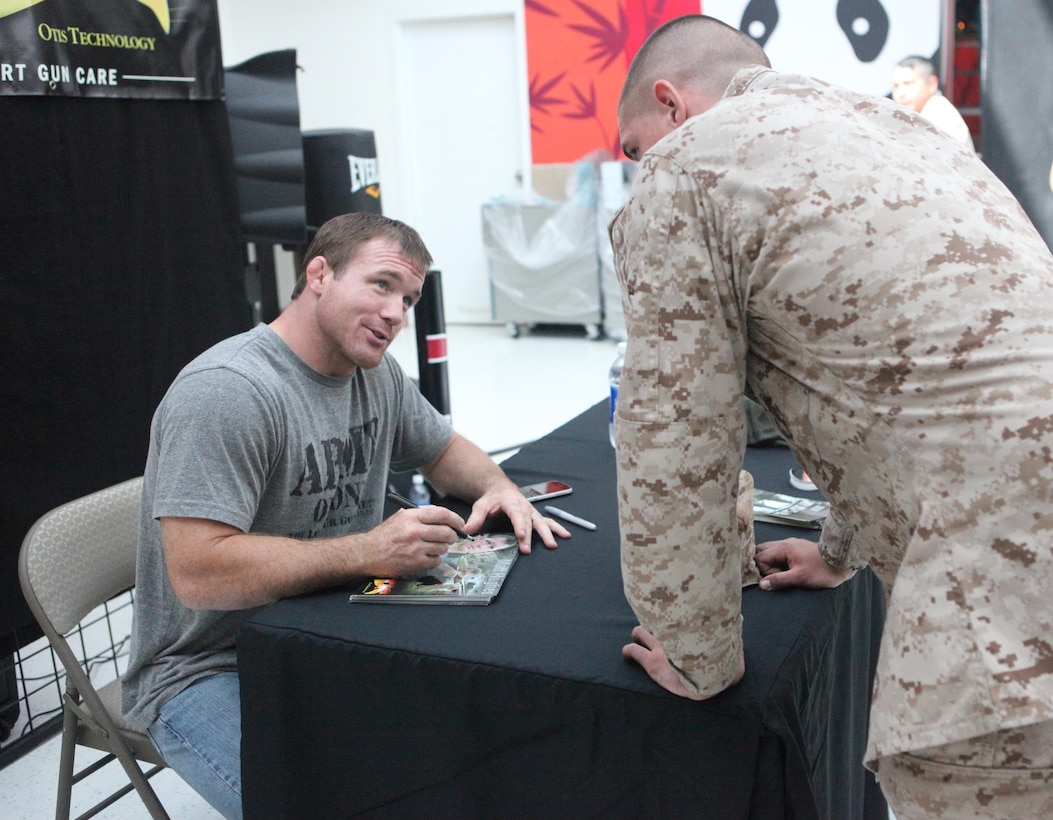 Matt Hughes, a professional mixed martial arts fighter, autographs a photo for a Marine at the Main Exchange aboard Marine Corps Base Camp Lejeune Oct. 25. Hughes’ visit was in conjunction with the tactical sales day held at the venue.  