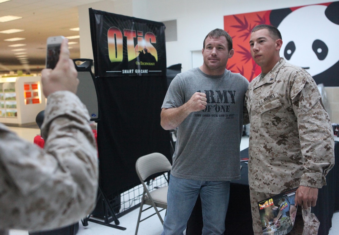 Matt Hughes, a professional mixed martial arts fighter, and Lance Cpl. Justin Cummins, a machine gunner with 2nd Battalion, 9th Marine Regiment, pose for a photo at the Main Exchange aboard Marine Corps Base Camp Lejeune Oct. 25. Hughes’ visit was in conjunction with the tactical sales day held at the venue.  