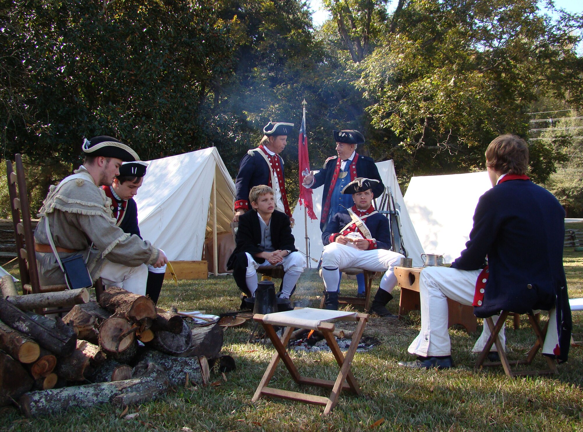Portraying soldiers of the American colonies, men and teens relax in their camp before the Battle of Camden re-enactment about 25 miles north of Shaw Air Force Base, at Camden, S.C., Nov. 3, 2012. More than 200 actors, including many military veterans, brought the battlefield back to life 232 years after the event. (U.S. Air Force photo by Rob Sexton/Released)