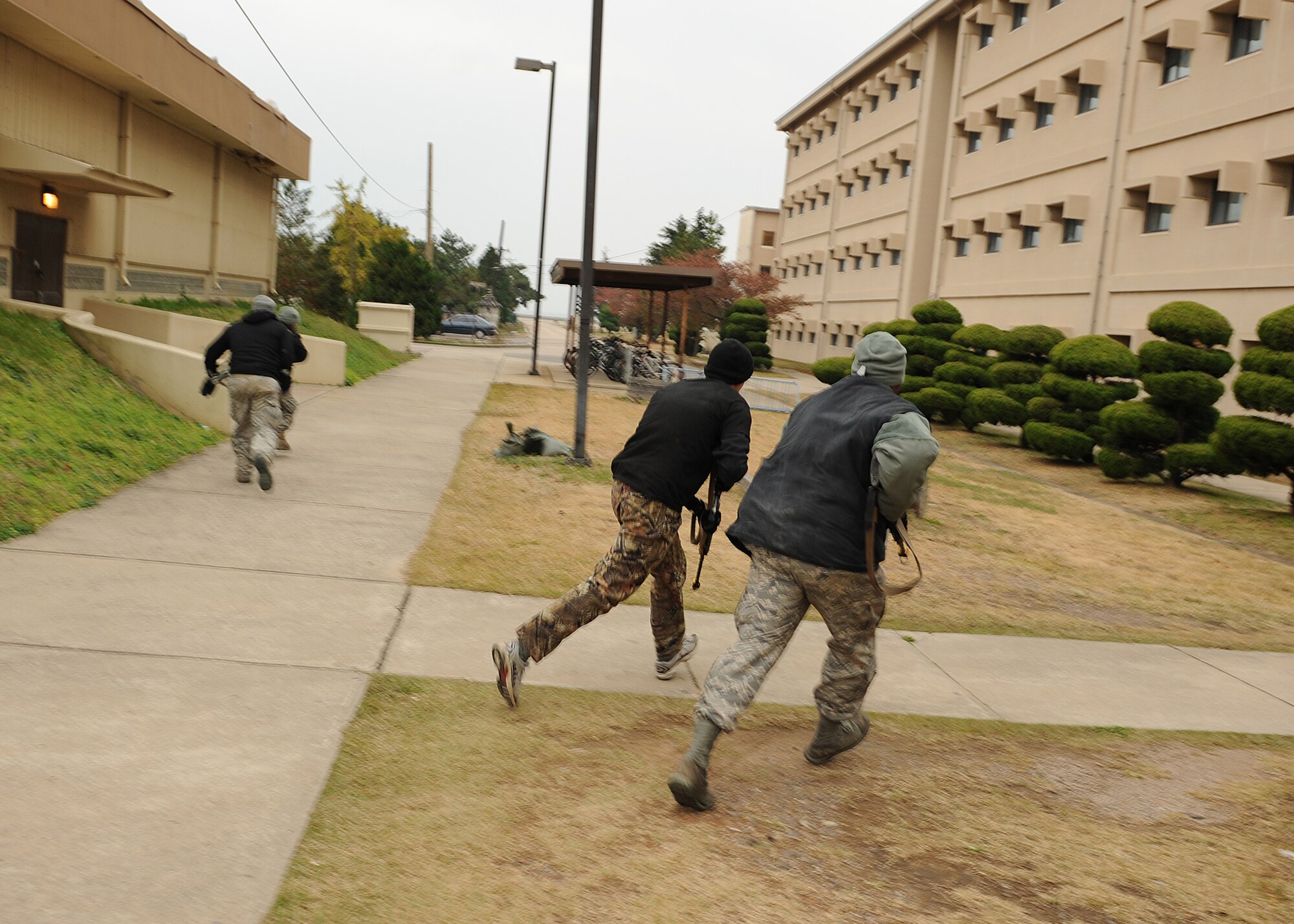 Opposing Forces role-players run for cover while attempting to infiltrate part of Kunsan Air Base, Republic of Korea during Beverly Bulldog 13-1, Nov. 6, 2012. Role-players provide OPFOR during exercises to simulate enemy and hostile personnel which makes the training more realistic for Wolf Pack emergency and security responders. (U.S. Air Force photo/Staff Sgt. Jonathan Fowler)