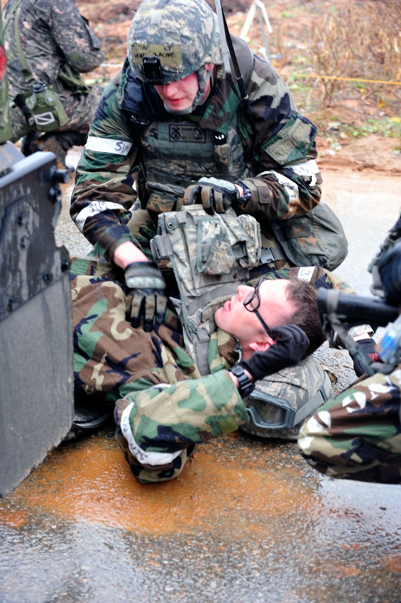 First Lt. Zachary Hunt administers self-aid and buddy care to Airman 1st Class Daniel Merchant, both with the 51st Security Forces Squadron, following a fire fight during operational readiness exercise Beverly Bulldog 13-01 at Osan Air Base, Republic of Korea, Nov. 6, 2012. Merchant suffered from a simulated shrapnel-inflicted sucking chest wound and was provided care on scene before being transported to the emergency room. (U.S. Air Force photo/Airman 1st Class Alexis Siekert)
