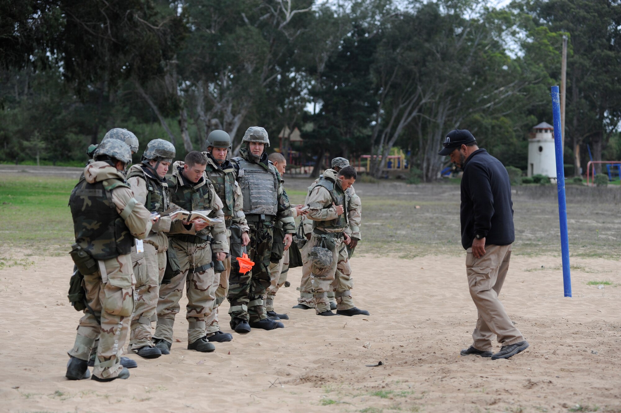 VANDENBERG AIR FORCE BASE, Calif. -- A line of Vandenberg Airmen under the supervision of Nelson Almodovar, 30th Civil Engineer Squadron Explosive Ordnance Disposal trainer, conduct a sweep to identify and mark unexploded ordnances during deployment readiness training at Cocheo Park Thursday, Nov. 1, 2012. Explosive Ordnance Disposal is one of many essential skills on which Airmen are evaluated as they prepare for deployment. (U.S. Air Force photo/Michael Peterson).