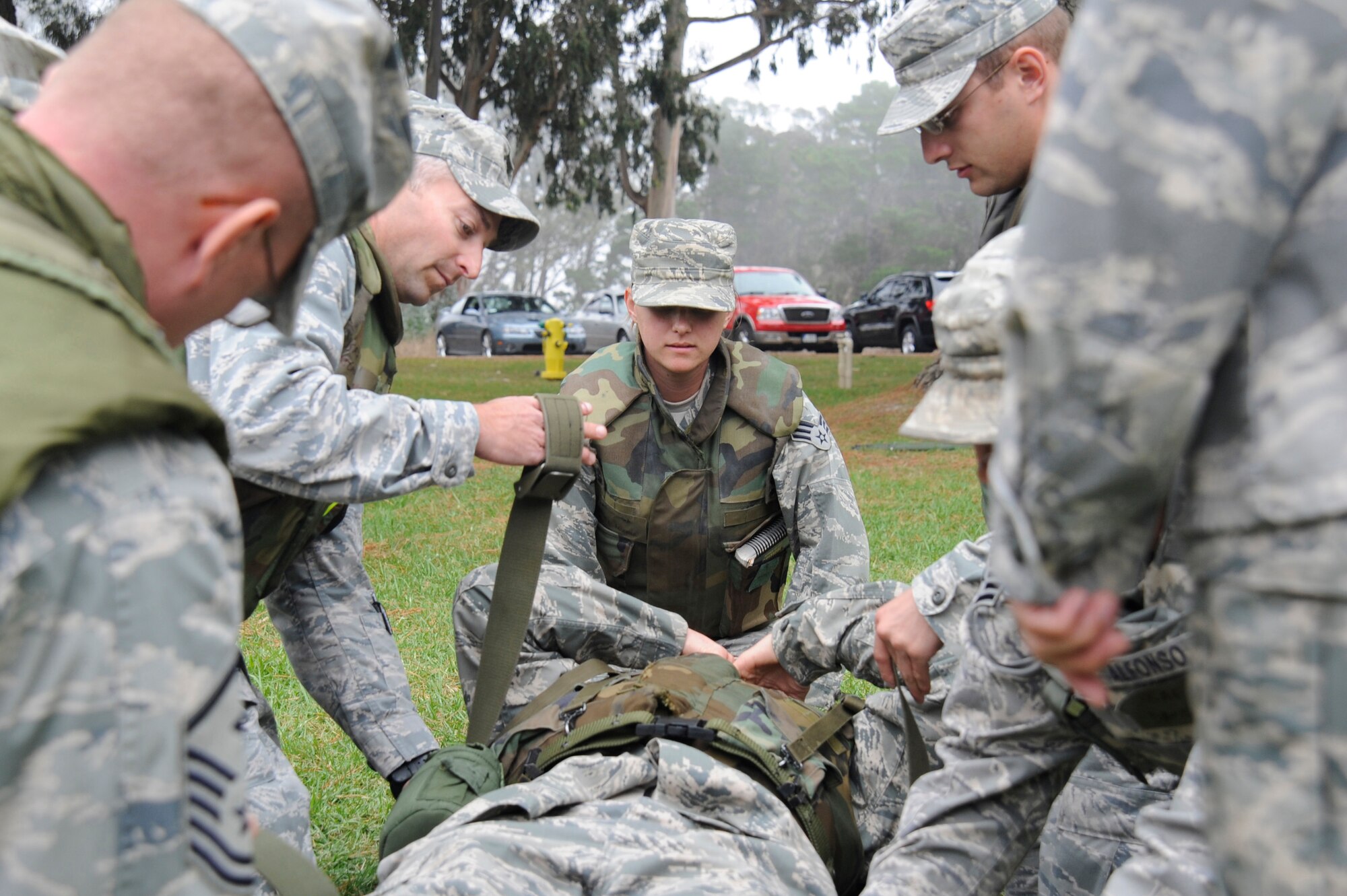 VANDENBERG AIR FORCE BASE, Calif. -- Senior Airman Felicia Aegerter, 30th Civil Engineer Squadron drafting technician, secures the end of a stretcher while her fellow team members prepare a wounded Airman for transport during deployment readiness training at Cocheo Park Thursday, Nov. 1, 2012. Stretcher transport is part of Self-Aid and Buddy Care, and is one of many skills on which Airmen are evaluated as they prepare for deployment. (U.S. Air Force photo/Michael Peterson)