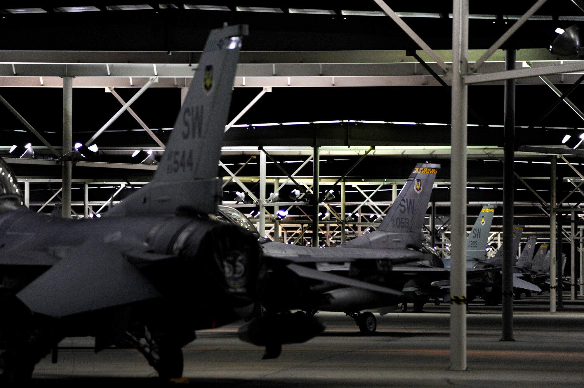 Several U.S. Air Force F-16 Fighting Falcon jets are parked under overhangs across the Shaw flight line, Oct. 10, 2012. Several of the F-16’s where prepped and launched in support of a deployment to an undisclosed location in Southwest Asia. (U.S. Air Force photo by Staff Sgt. Kenny Holston/Released) 