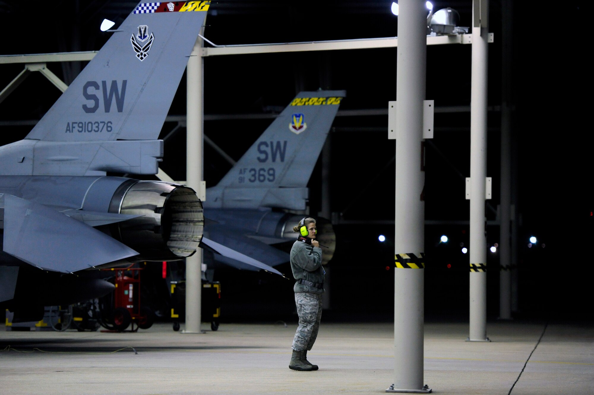 U.S. Air Force Lt. Col. Leah Fry, 20th Aircraft Maintenance Squadron commander, peers across the Shaw flight line while listening to radio transmissions amongst maintainers and crew chiefs and other unit commanders as F-16 Fighting Falcons are prepped take-off, Oct. 10, 2012, Shaw Air Force Base, S.C. Several Team Shaw Airmen and F-16 fighter pilots from the 77th Fighter Squadron deployed from Shaw to an undisclosed location in Southwest Asia. (U.S. Air Force photo by Staff Sgt. Kenny Holston/Released)