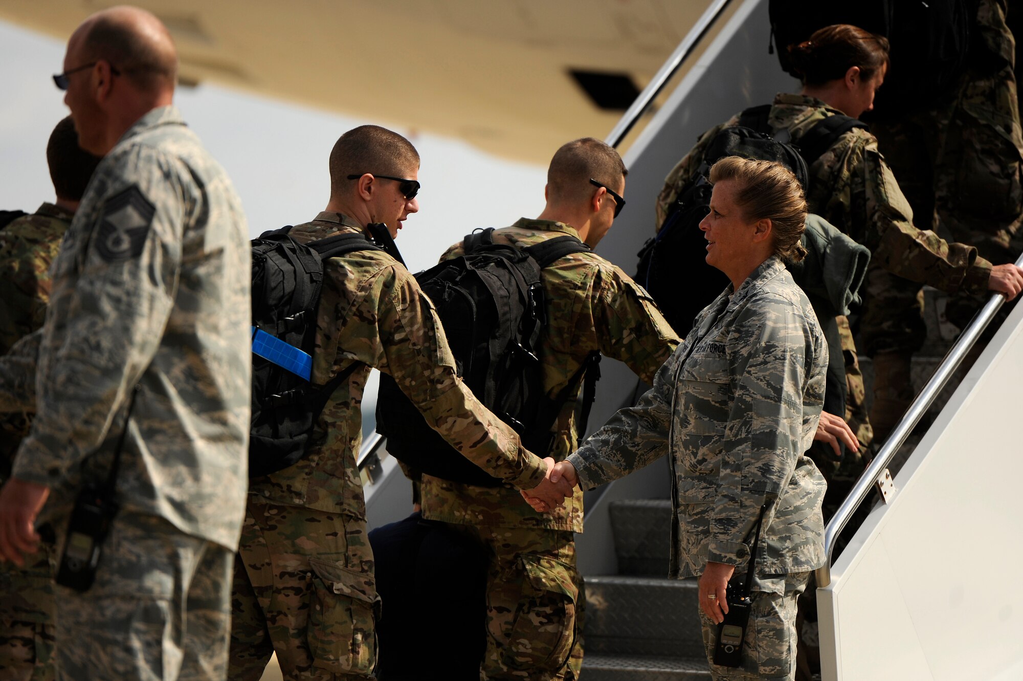 U.S. Air Force Col. Helen Brasher, 20th Maintenance Group commander, (right) shakes the hands of Airmen assigned to her unit as they load a multi passenger aircraft for a deployment, Oct. 10, 2012, Shaw Air Force Base, S.C. Several Team Shaw Airmen and F-16 fighter pilots from the 77th Fighter Squadron deployed from Shaw to an undisclosed location in Southwest Asia. (U.S. Air Force photo by Staff Sgt. Kenny Holston/Released)  