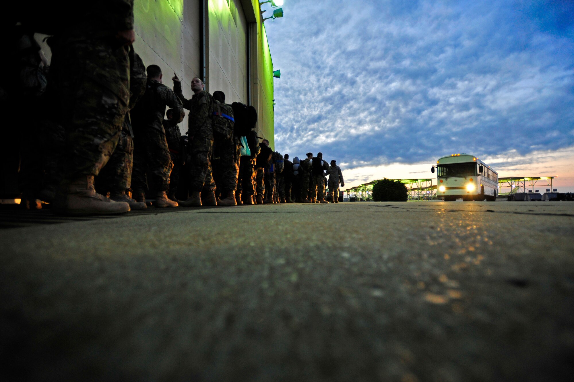 Blue clouds streak across the sky early in the morning while U.S. Air Force Airmen assigned to the 20th Fighter Wing wait to load a bus that will take them to their aircraft as they leave their home unit in route to an undisclosed deployed location, Oct. 10, 2012, Shaw Air Force Base, S.C. Several Team Shaw Airmen and F-16 fighter pilots from the 77th Fighter Squadron deployed from Shaw to an undisclosed location in Southwest Asia. (U.S. Air Force photo by Staff Sgt. Kenny Holston/Released)  