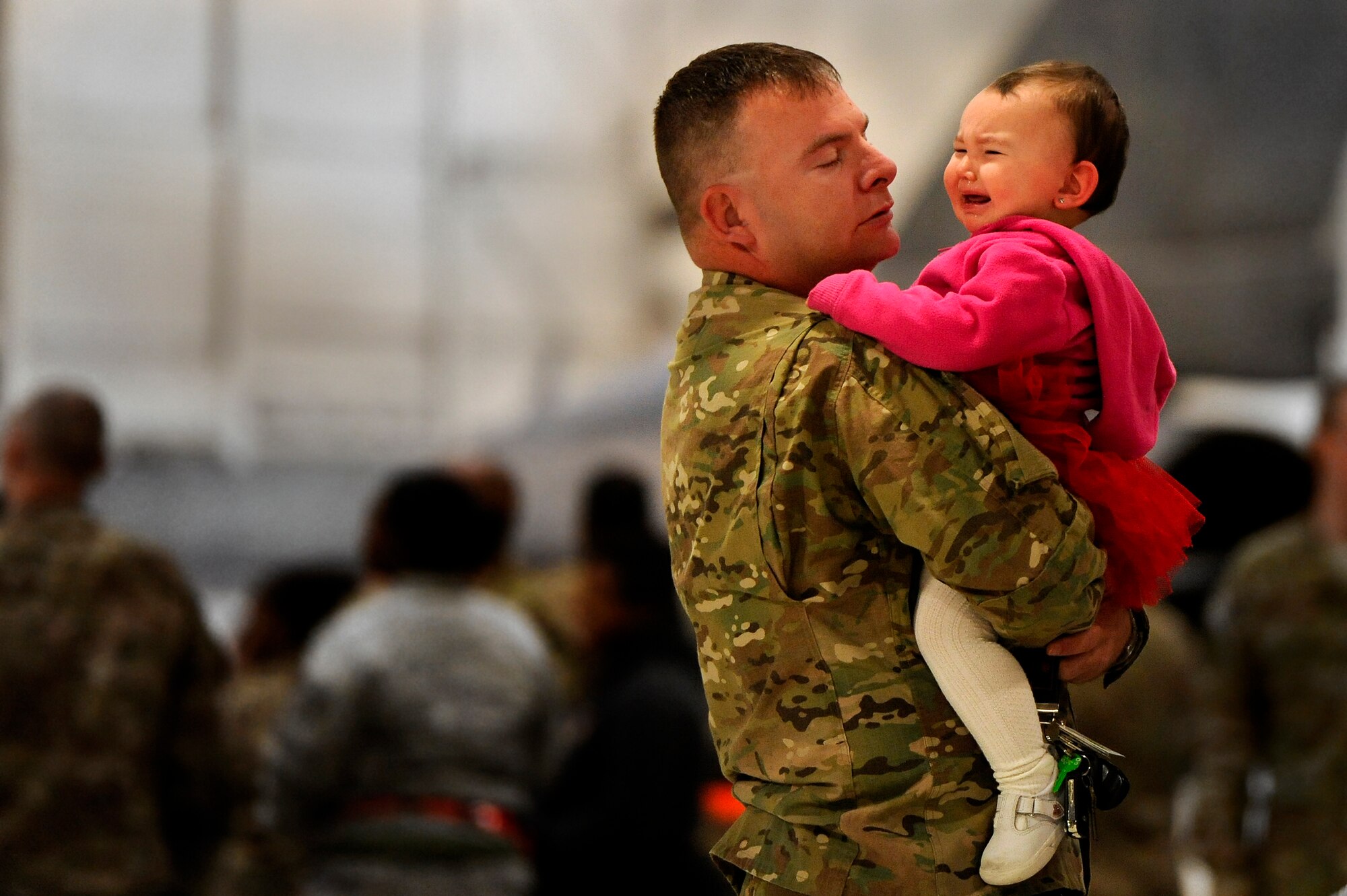 A U.S. Air Force Master Sgt. assigned to the 20th Maintenance Group tries to comfort his daughter while explaining to her that he is leaving for a deployment, Oct. 10, 2012, Shaw Air Force Base, S.C. Several Team Shaw Airmen and F-16 fighter pilots from the 77th Fighter Squadron deployed from Shaw to an undisclosed location in Southwest Asia. (U.S. Air Force photo by Staff Sgt. Kenny Holston/Released)