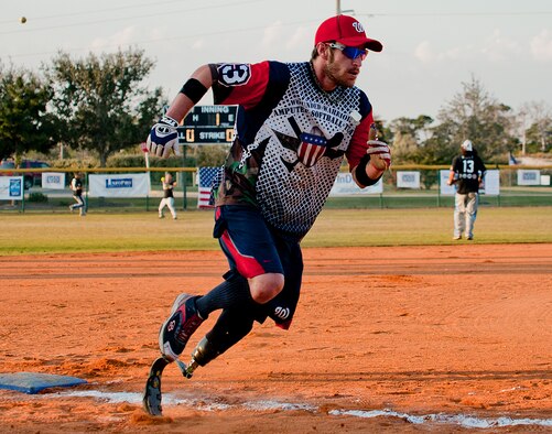 Nick Clark, a Wounded Warrior Amputee Softball Team player, turns for home plate as his Northwest Florida Military Softball opponent fields the ball at the Morgan Sports Center in Destin, Fla., Nov. 3rd. WWAST, consisting of service members who have lost limbs in battle, joined players from Eglin Air Force Base, Hurlburt Field and the Army 7th Special Forces Group, for a softball game in an effort to raise awareness of the sacrifices and resilience of military members. (U.S. Air Force photo/Randy Gon)