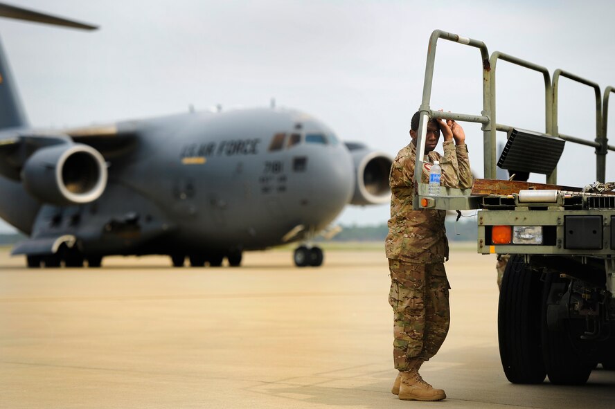 U.S. Air Force Airman 1st Class Matthew Galbreath, 20th Operations Support Squadron leans against a cargo trailer while waiting for a second C-17 Globemaster III to taxi into place so cargo can be loaded on to it in support of an upcoming deployment, Oct. 5, 2012, Shaw Air Force Base, S.C. Several Team Shaw Airmen and F-16 fighter pilots from the 77th Fighter Squadron deployed from Shaw to an undisclosed location in Southwest Asia. (U.S. Air Force photo by Staff Sgt. Kenny Holston/Released) 
