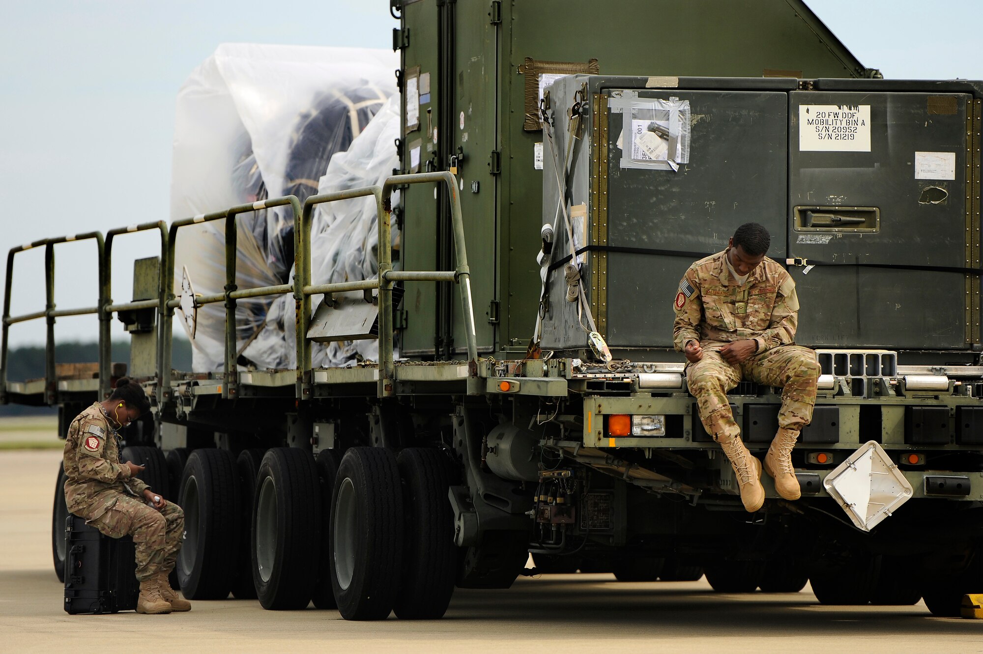 U.S. Air Force Senior Airmen Ebony Starr and Airman 1st Class Matthew Galbreath, both assigned to the 20th Operations Support Squadron sit on the Shaw flight line while waiting to help load cargo on to a C-17 Globemaster III in support of an upcoming deployment, Oct. 5, 2012, Shaw Air Force Base, S.C. Several Team Shaw Airmen and F-16 fighter pilots from the 77th Fighter Squadron deployed from Shaw to an undisclosed location in Southwest Asia. (U.S. Air Force photo by Staff Sgt. Kenny Holston/Released) 