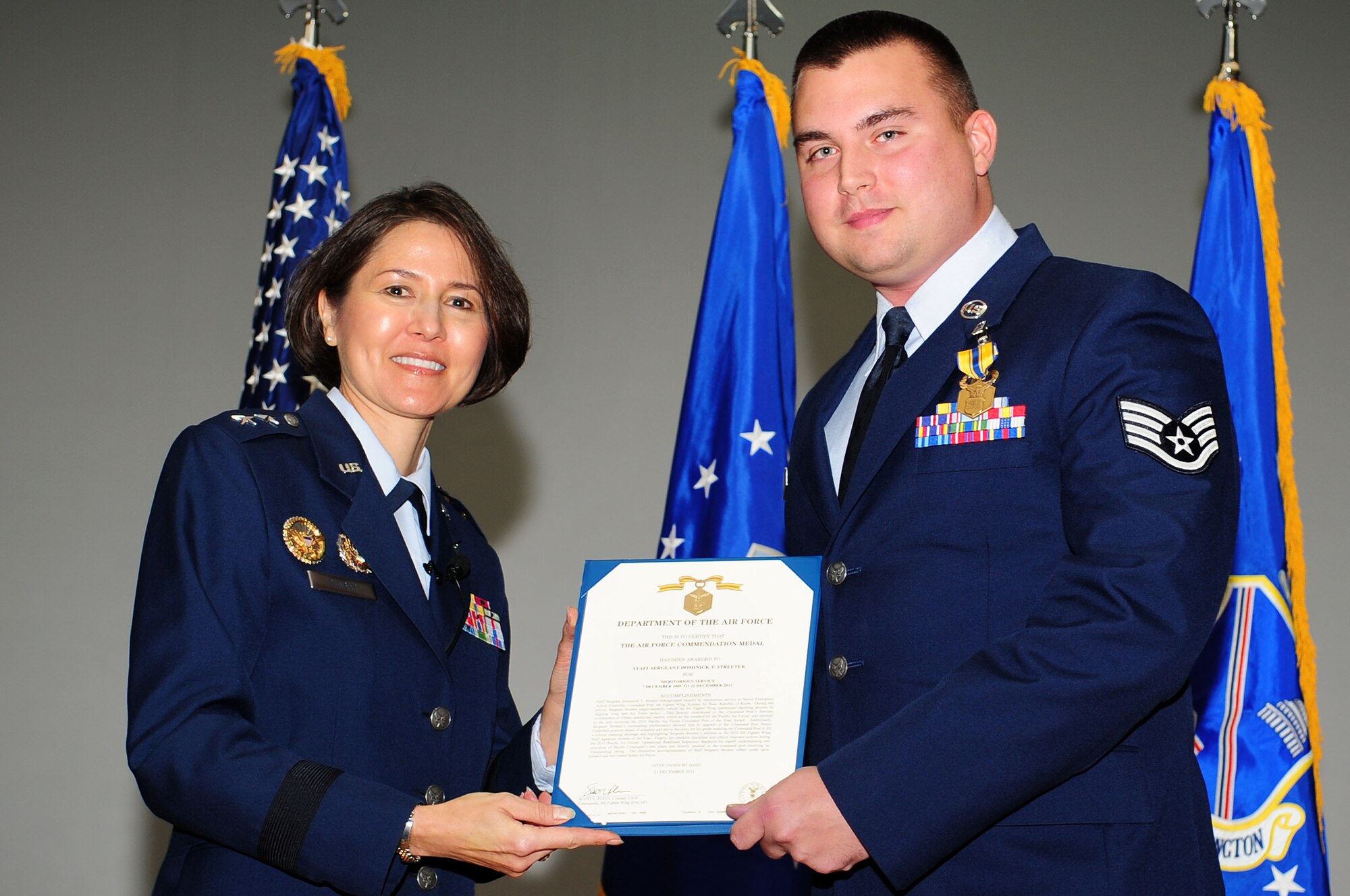 Air Force District of Washington Commander Maj. Gen. Sharon K. G. Dunbar presents the Air Force Achievement Medal to Staff Sgt. Dominick Streeter, AFDW Operations Directorate, during a commander's call at the base theater, Nov. 5, at Joint Base Andrews, Md. Streeter was awarded the medal for his accomplishments while stationed at Kunsan Air Base, Korea. (U.S. Air Force photo by Senior Airman Steele C. G. Britton)