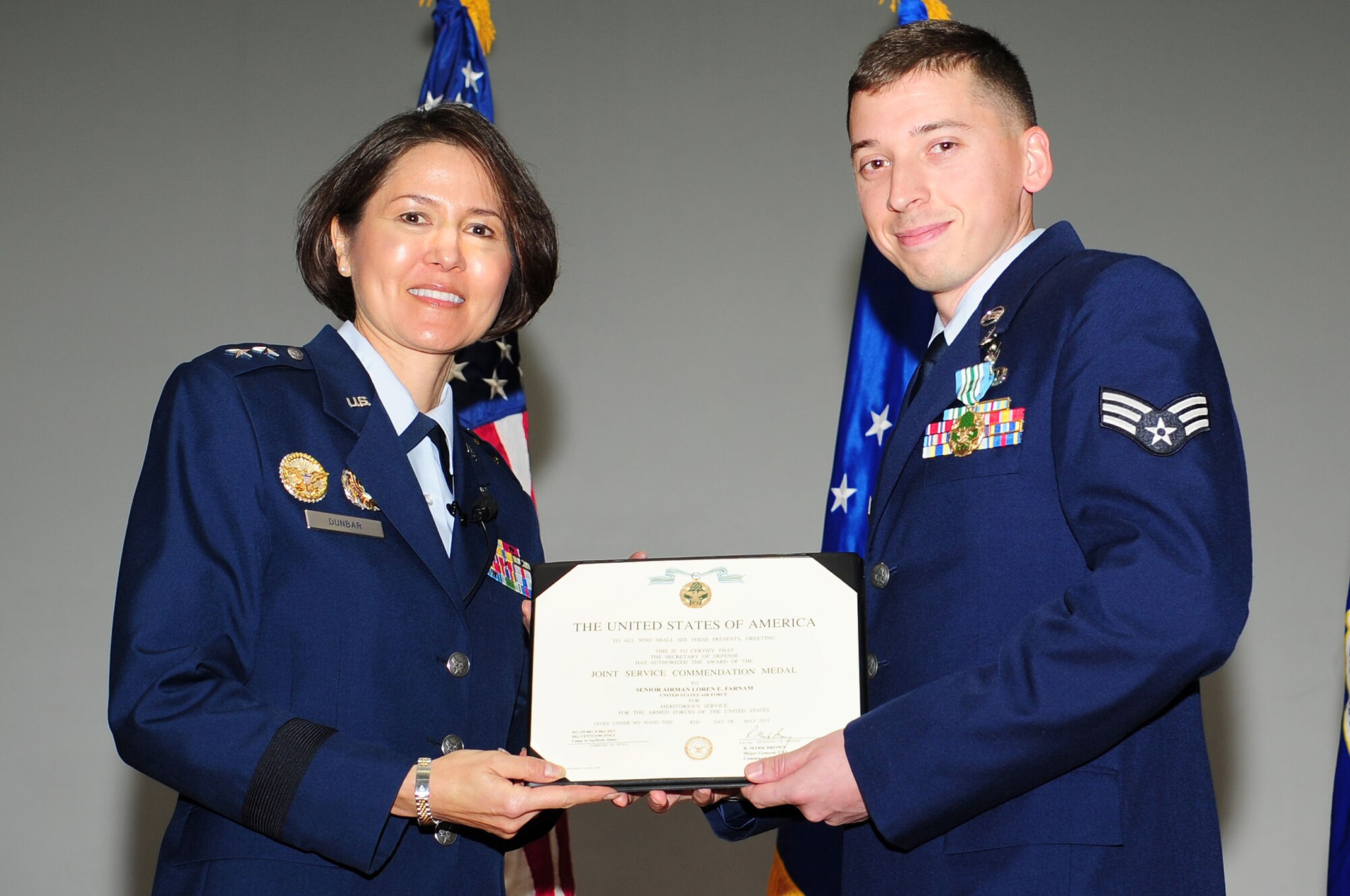 Air Force District of Washington Commander Maj. Gen. Sharon K. G. Dunbar presents the Joint Service Commendation Medal to Senior Airman Loren Farnam, AFDW Contracting, during a commander's call at the base theater, Nov. 5, at Joint Base Andrews, Md. Farnam was presented the medal for his accomplishments during a recent deployment in support of Operation Enduring Freedom. (U.S. Air Force photo by Senior Airman Steele C. G. Britton)