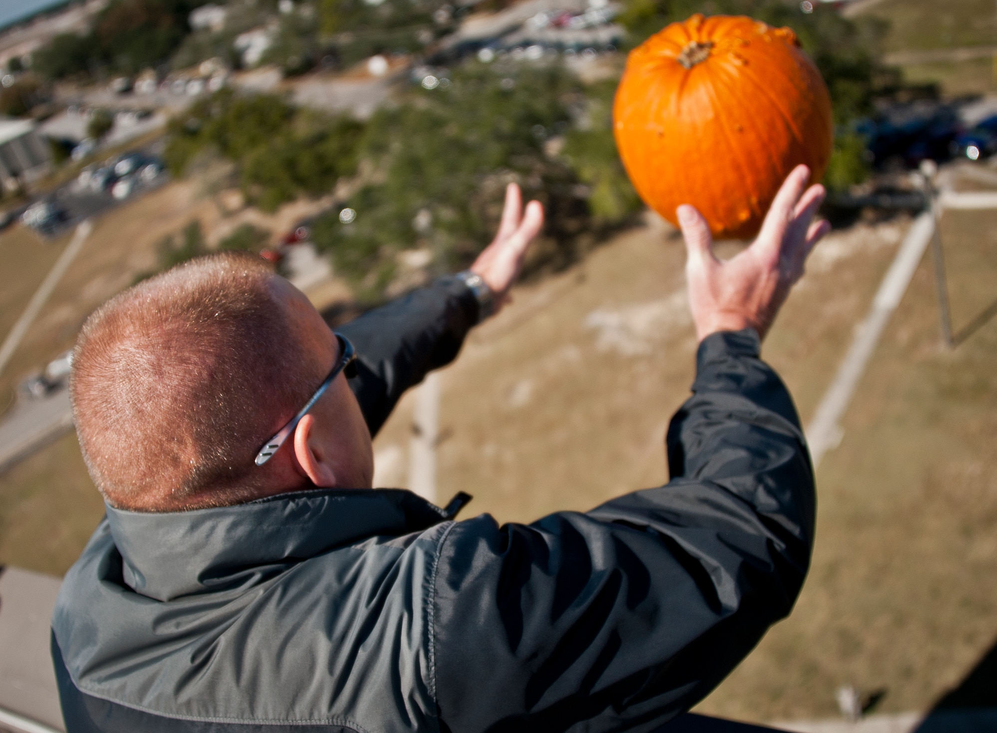 A Team Eglin member tosses a pumpkin off of Bldg. 350 toward a target on the ground during the 9th Annual Pumpkin Toss at Eglin Air Force Base, Fla., Nov. 6. Participants paid $5 for each toss.  Proceeds from the event, went to a Combined Federal Campign charity. (U.S. Air Force photo/Randy Gon)